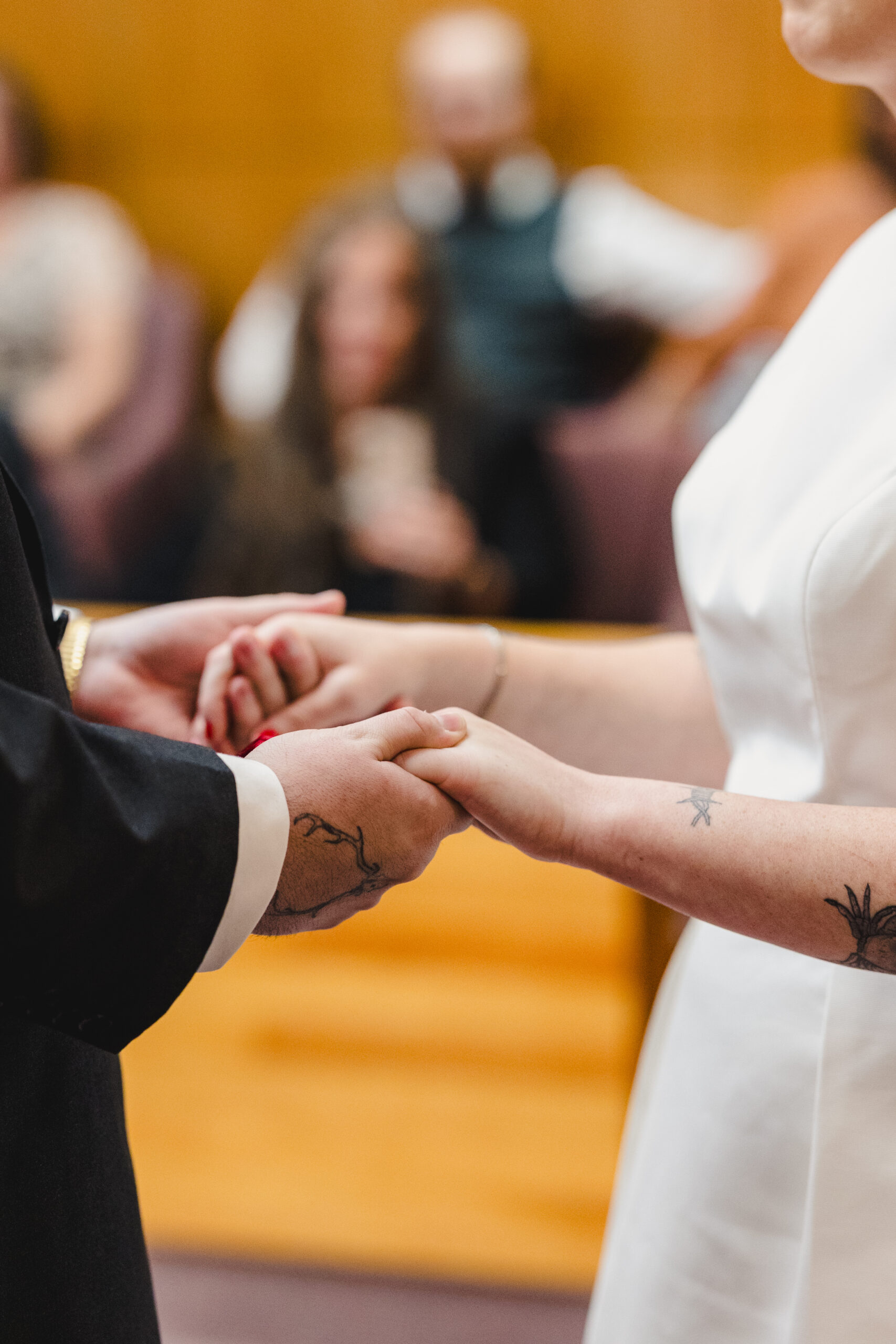 a couple holding hands and looking at each other at their courthouse wedding