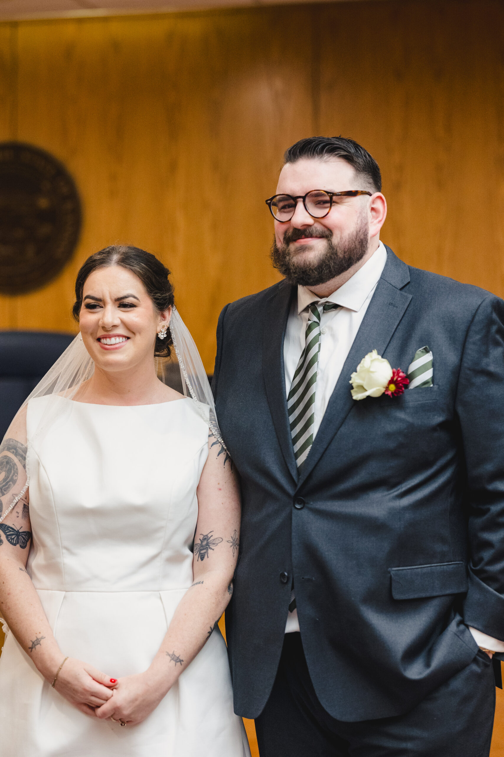a couple standing side by side and smiling at their wedding in the courthouse 
