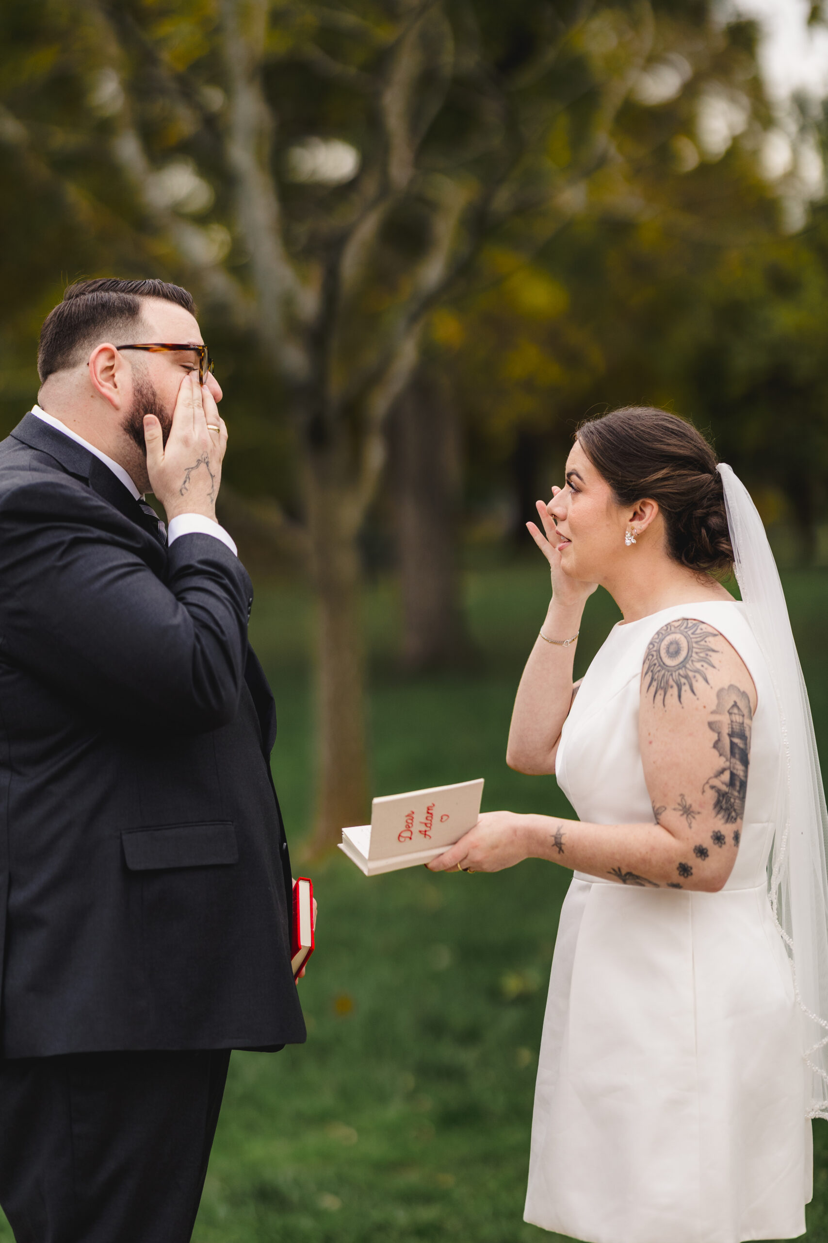 a man and woman reading privatge vows to each other and getting teary eyed 