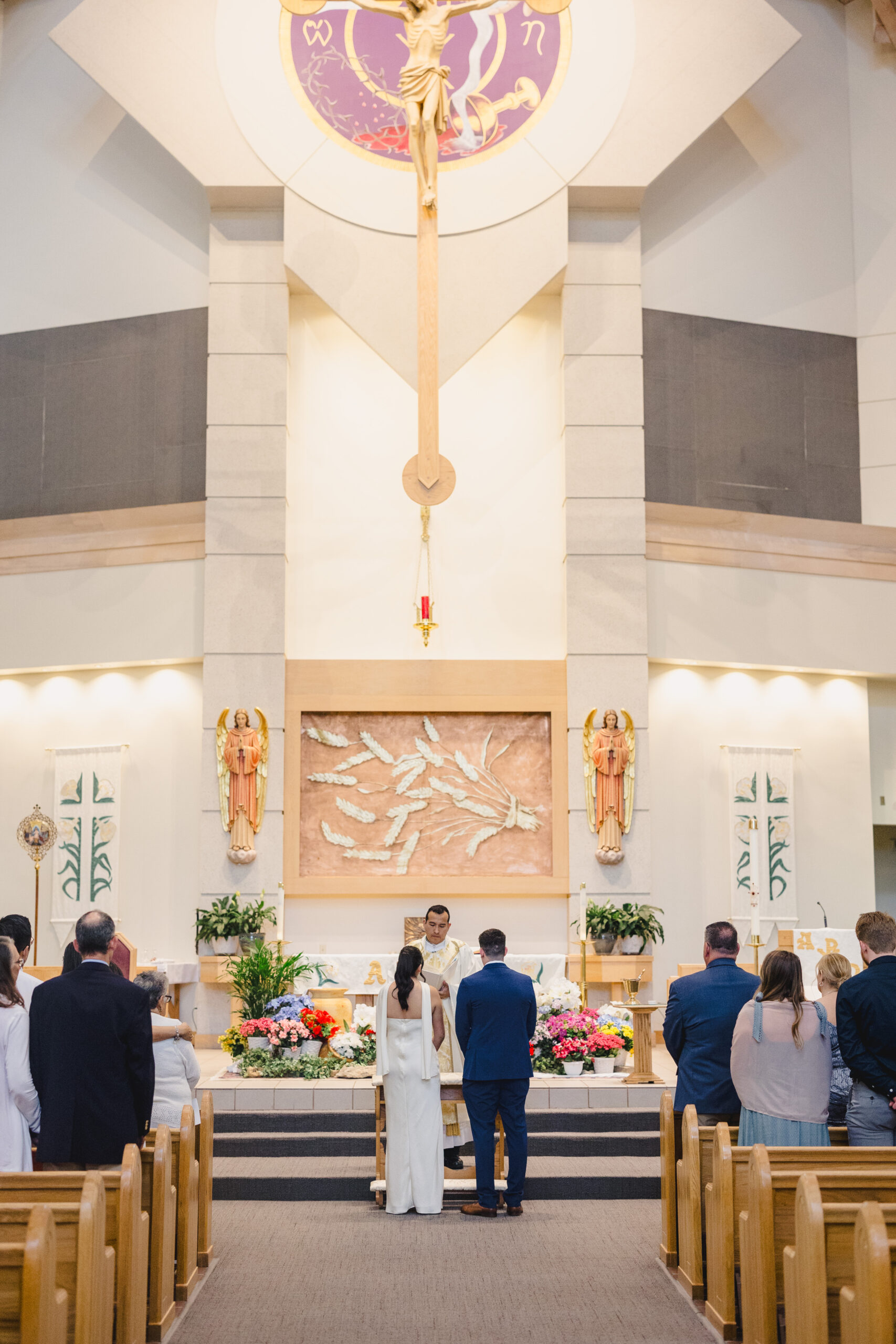 a bride and groom in a church having their wedding ceremony with an altar in fron tof them 
