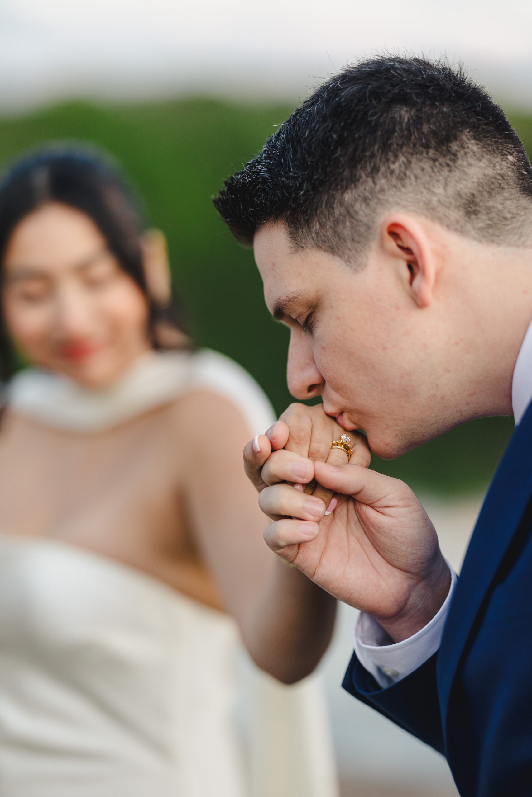 a groom kissing his bride's hand 