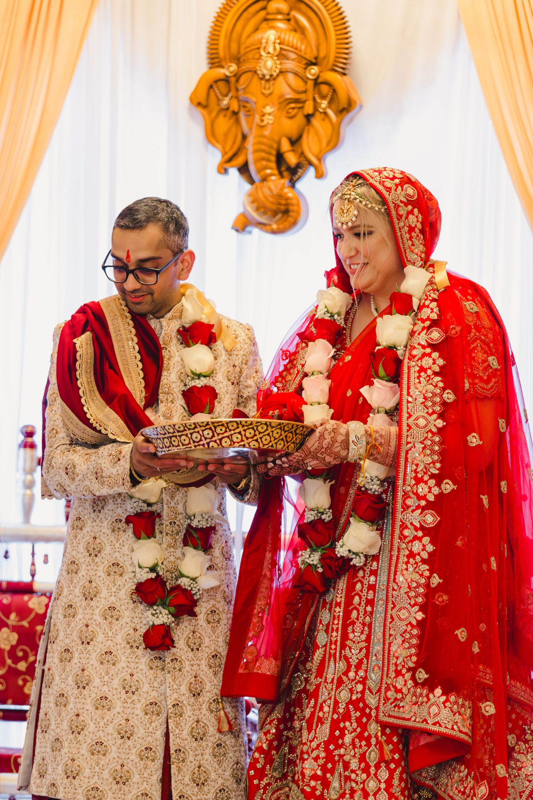 a couple having a traditional indian wedding ceremony inside of loose mansion 