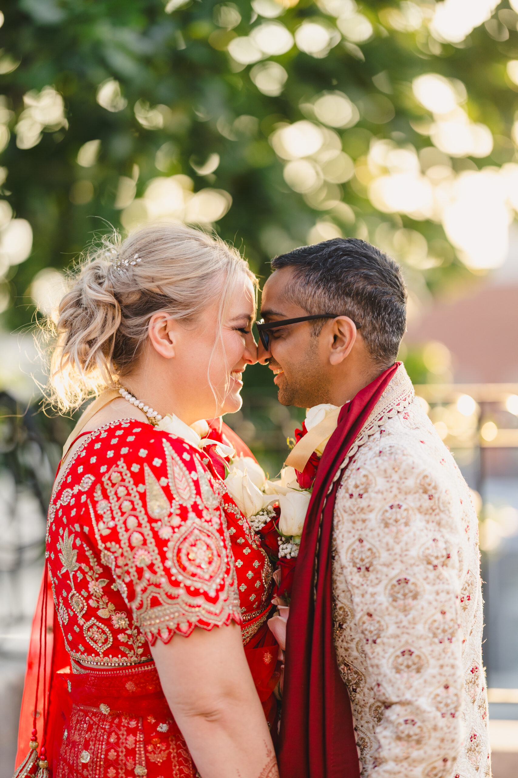 a couple taking golden hour photos outside of loose mansion their noses are pressed together and they are both smiling 