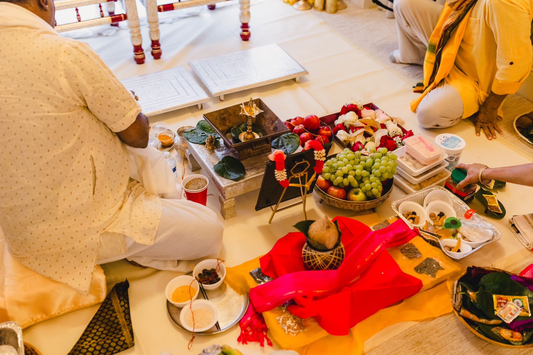 a variety of food on the ground for a traditional indian wedding ceremony including fruits, bread, and sauces 