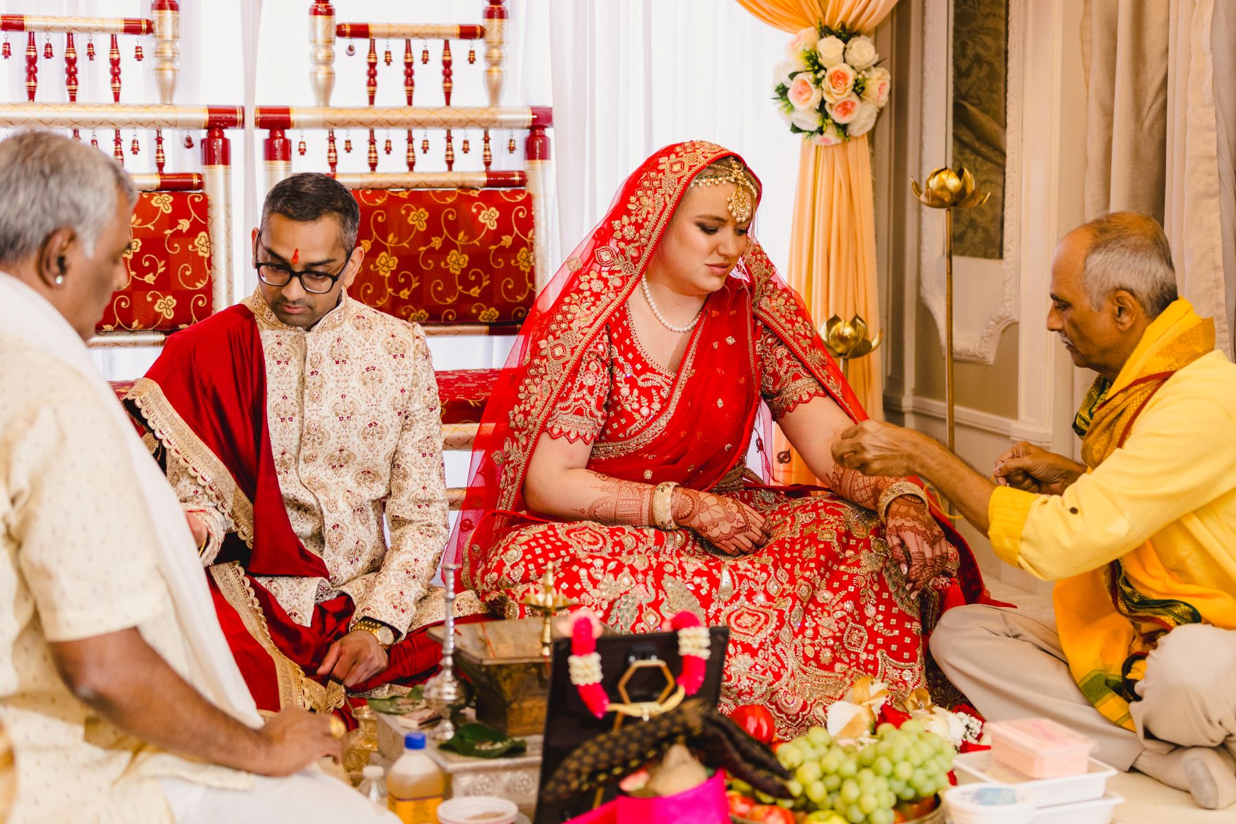 a couple sitting on the ground for a traditional indian wedding ceremony 