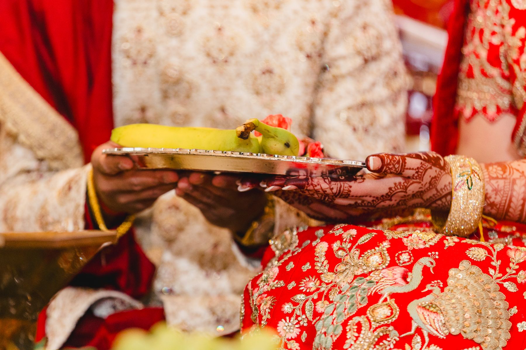 a couple sitting on the ground and holding a plate with a banana on it 