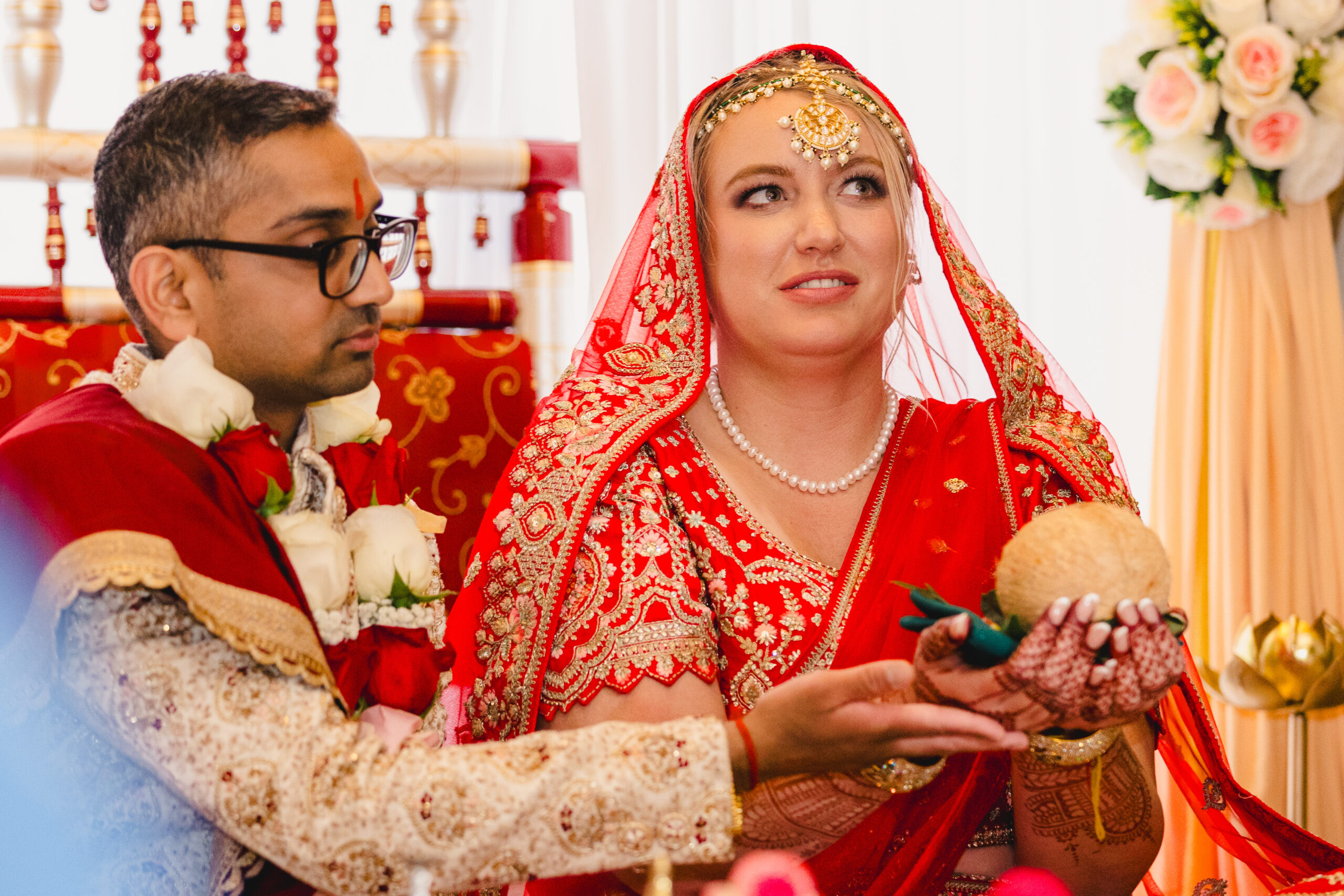a couple sitting on the ground during their indian wedding ceremony 