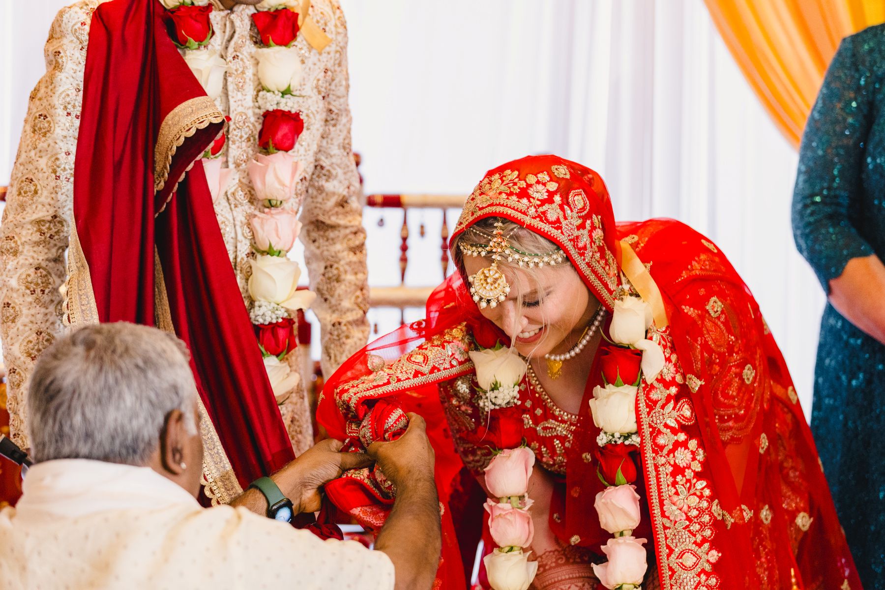 a man touching the brid'es shwal during a traditional indian wedding ceremony