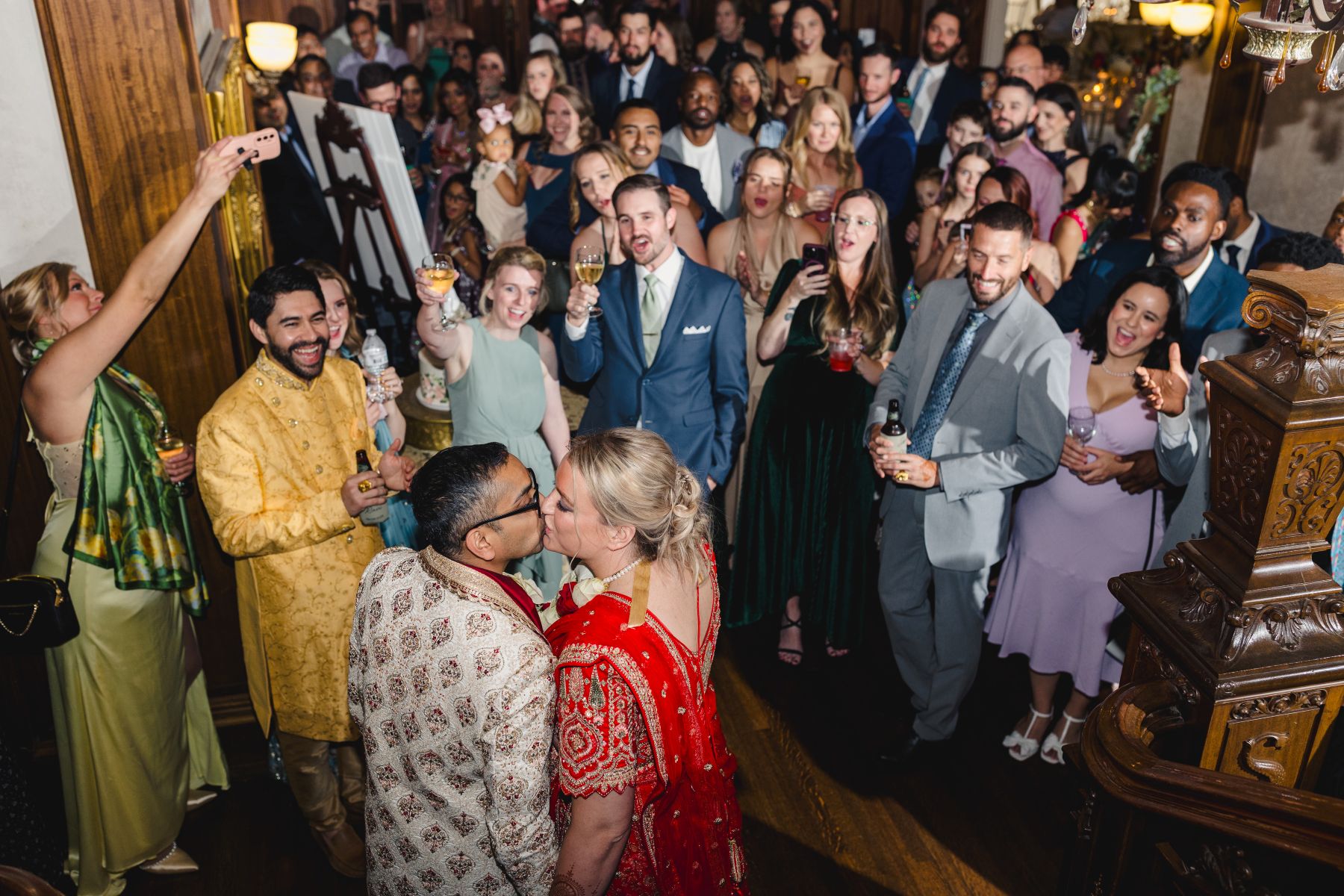 a couple kissing at their wedding reception in front of their guests at loose mansion 