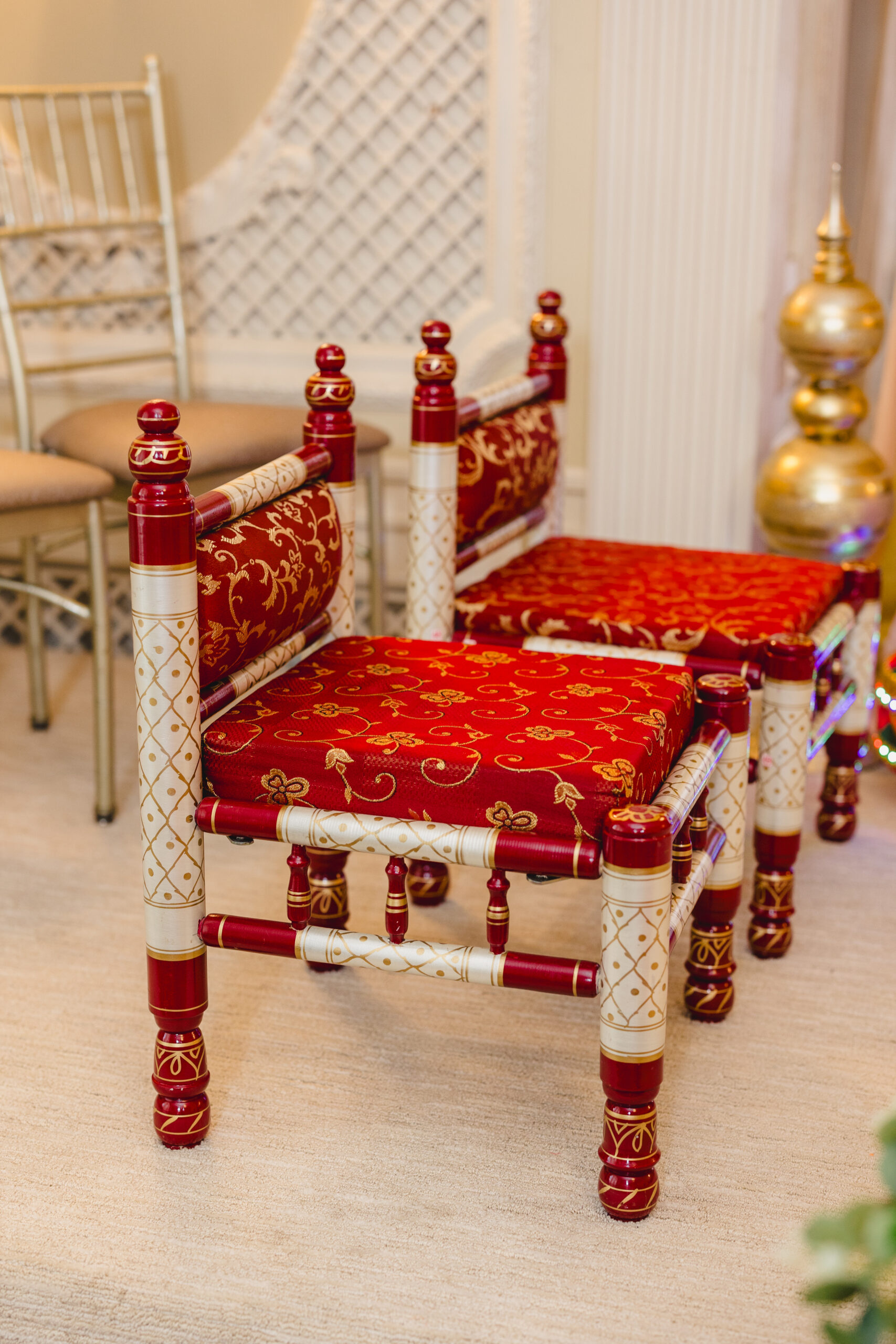 two small red chairs set up for a wedding ceremony