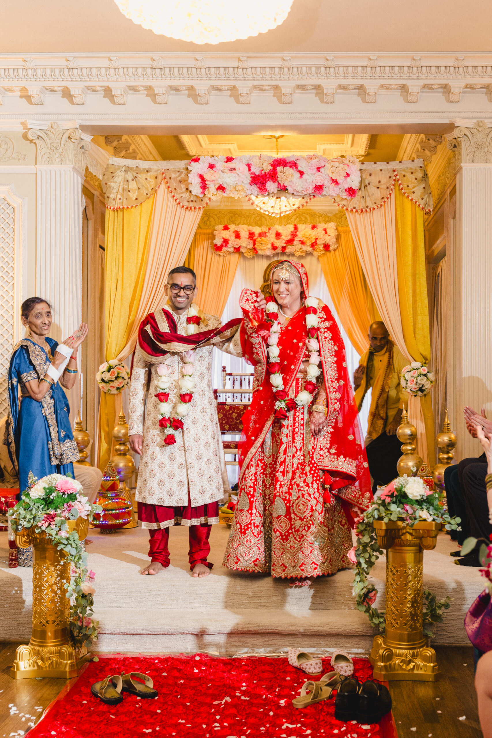 a couple holding hands and celebrating after their wedding ceremony inside of loose mansion 