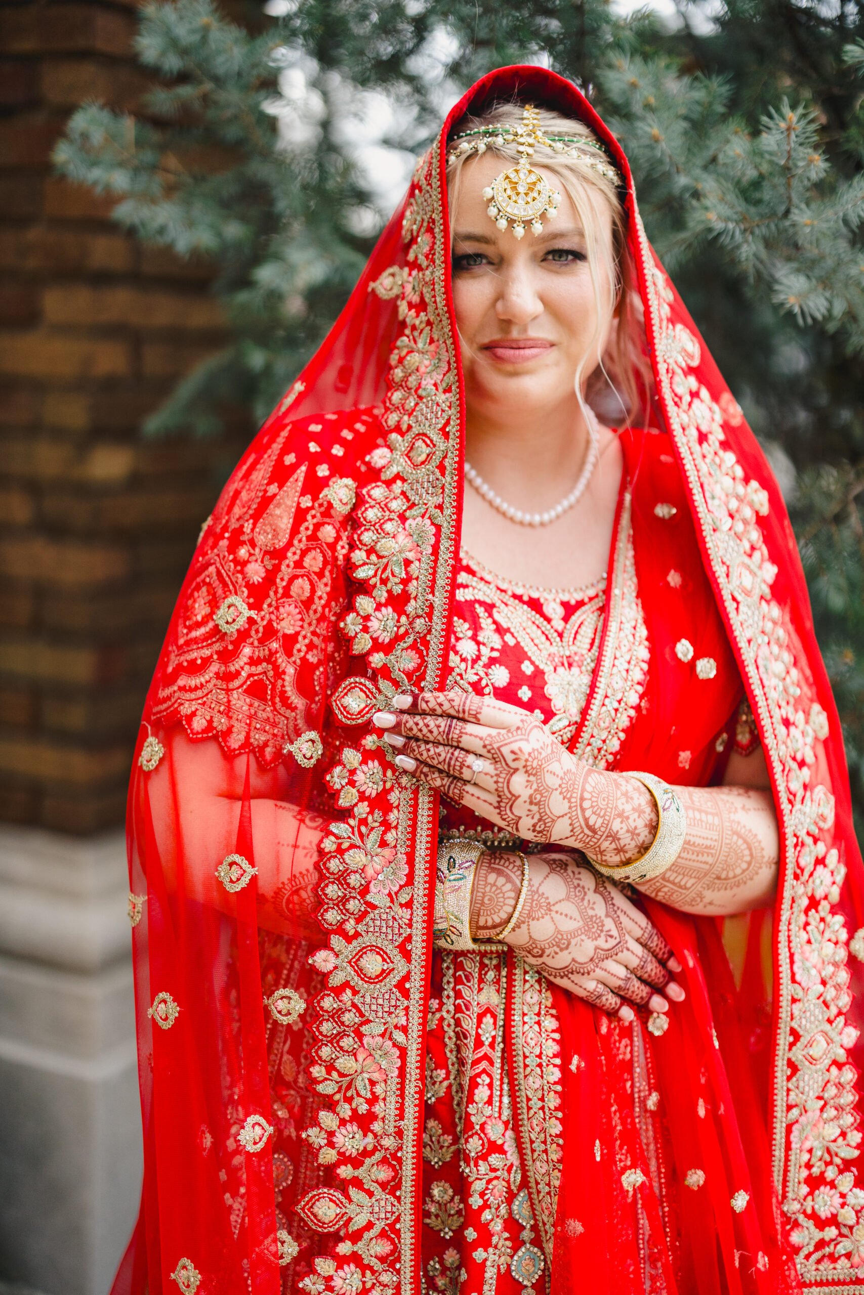 a woman wearing traditional indian attire for her wedding with henna on her hands 
