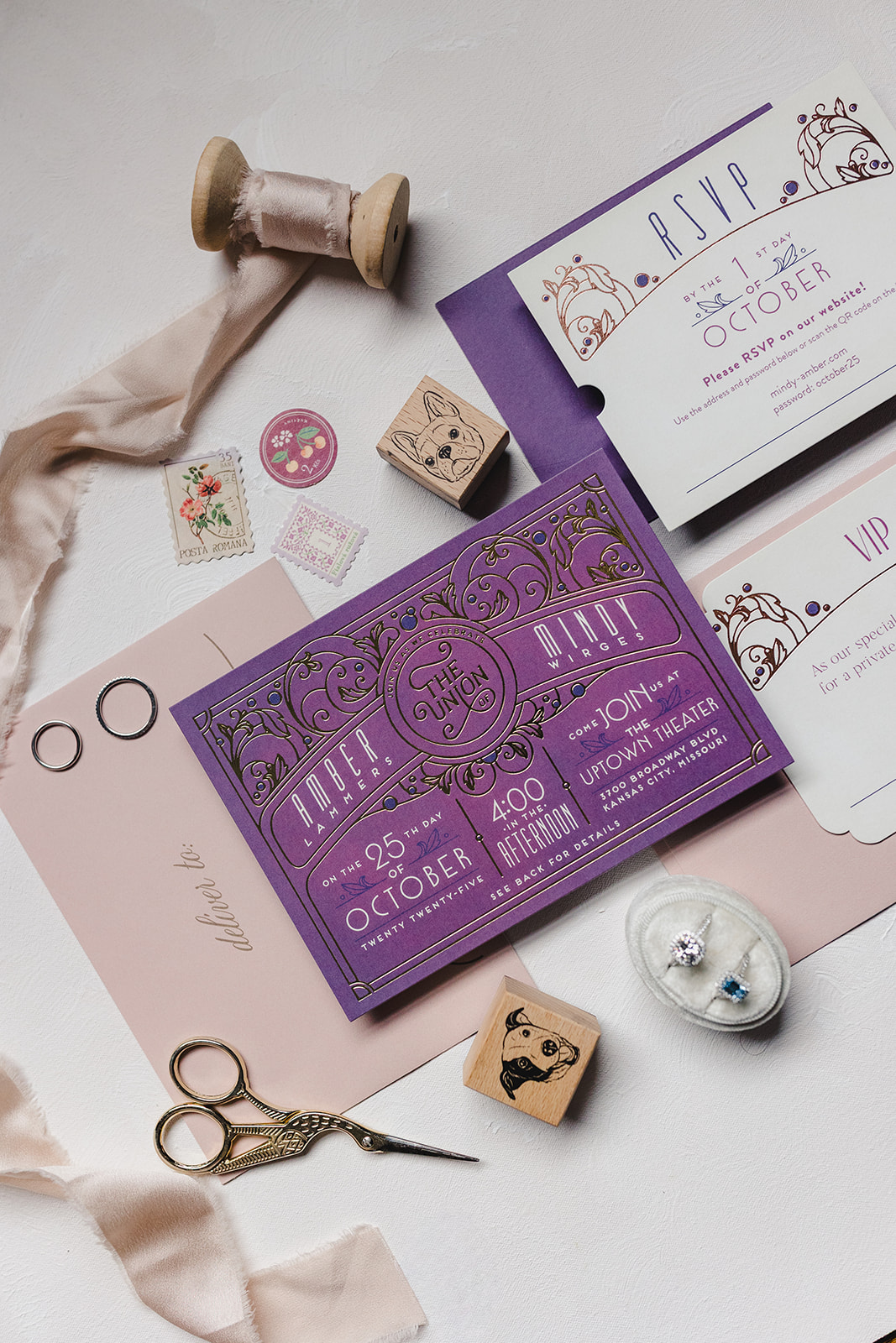 a flat lay featuring different wedding detail items including stamps, rings, scissors, ribbons,and wedding invitations 