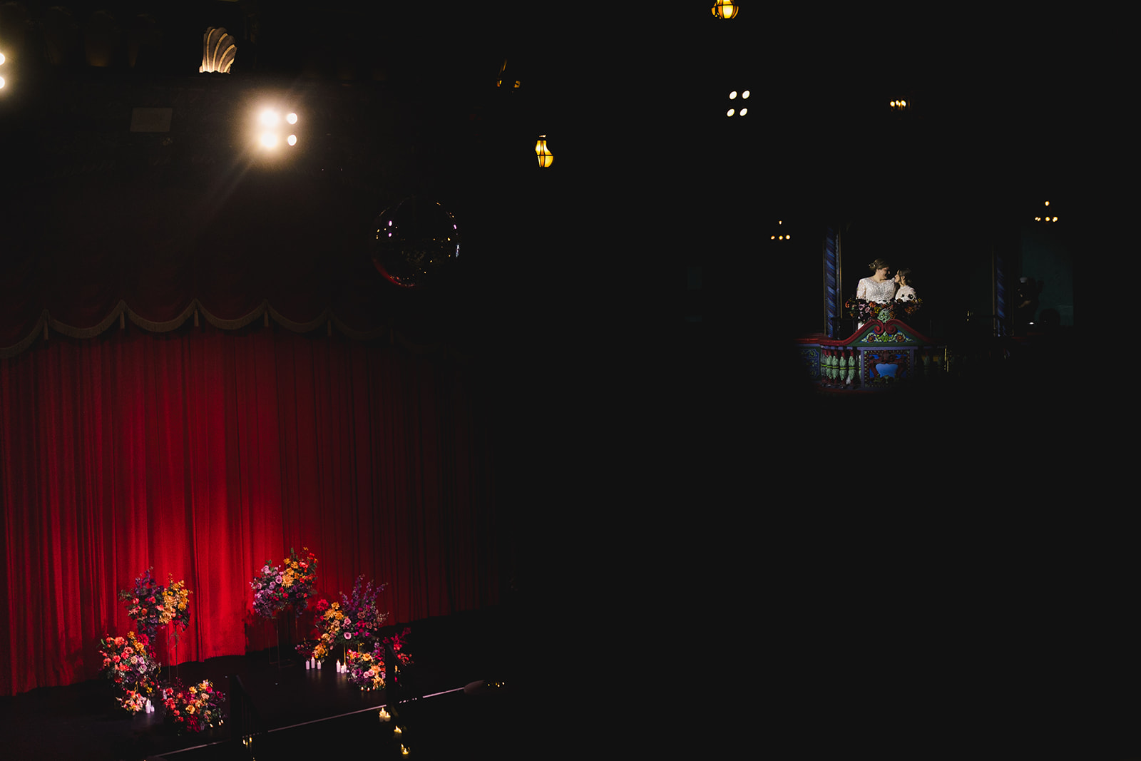 two brides taking wedding portraits inside of uptown theater in kansas city 