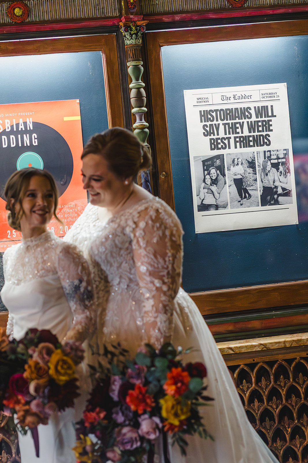 two brides taking wedding day portraits inside of the uptown theater in kansas city 