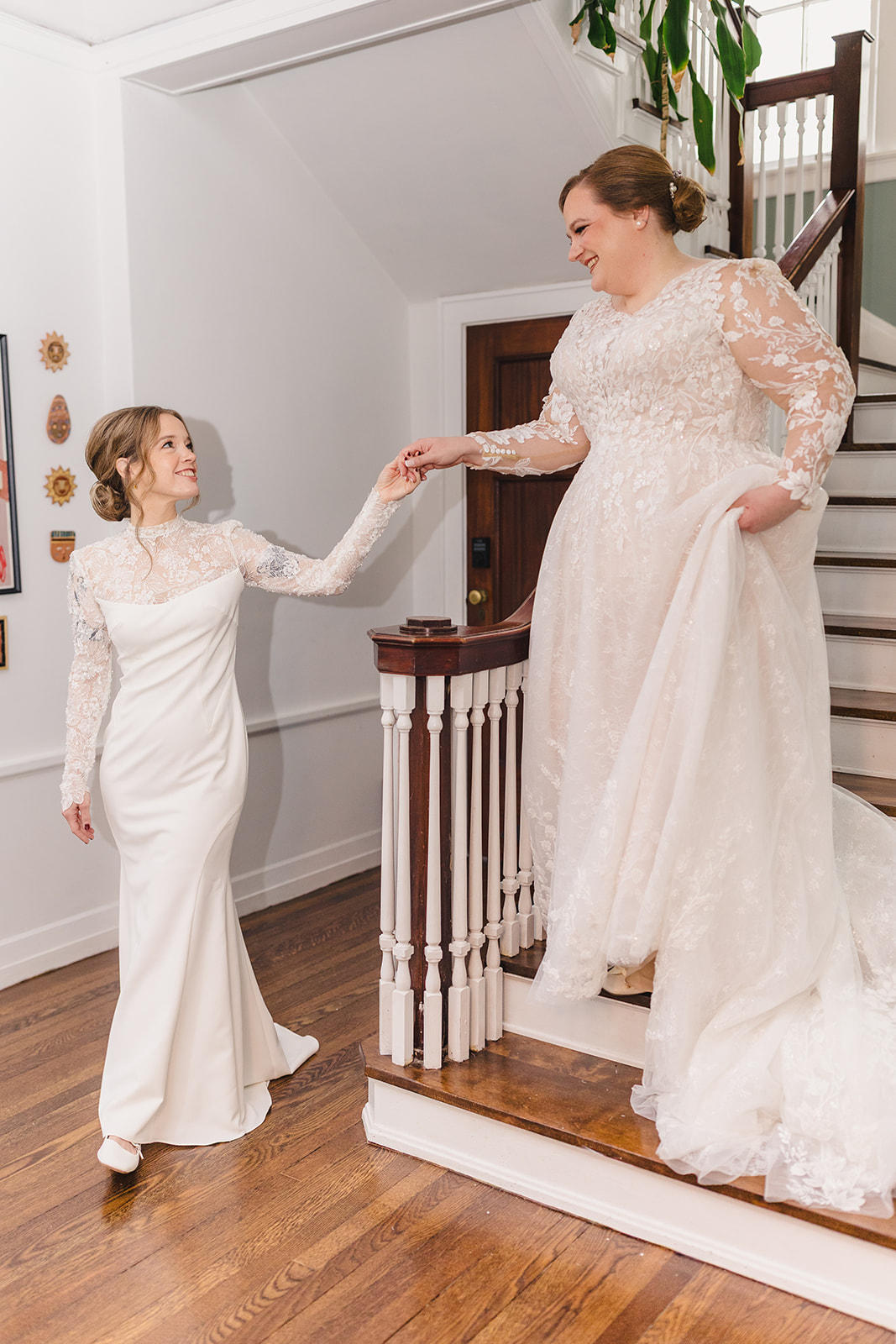 two bride together sharing a first look one bride is walking down the stairs to greet the other bride 