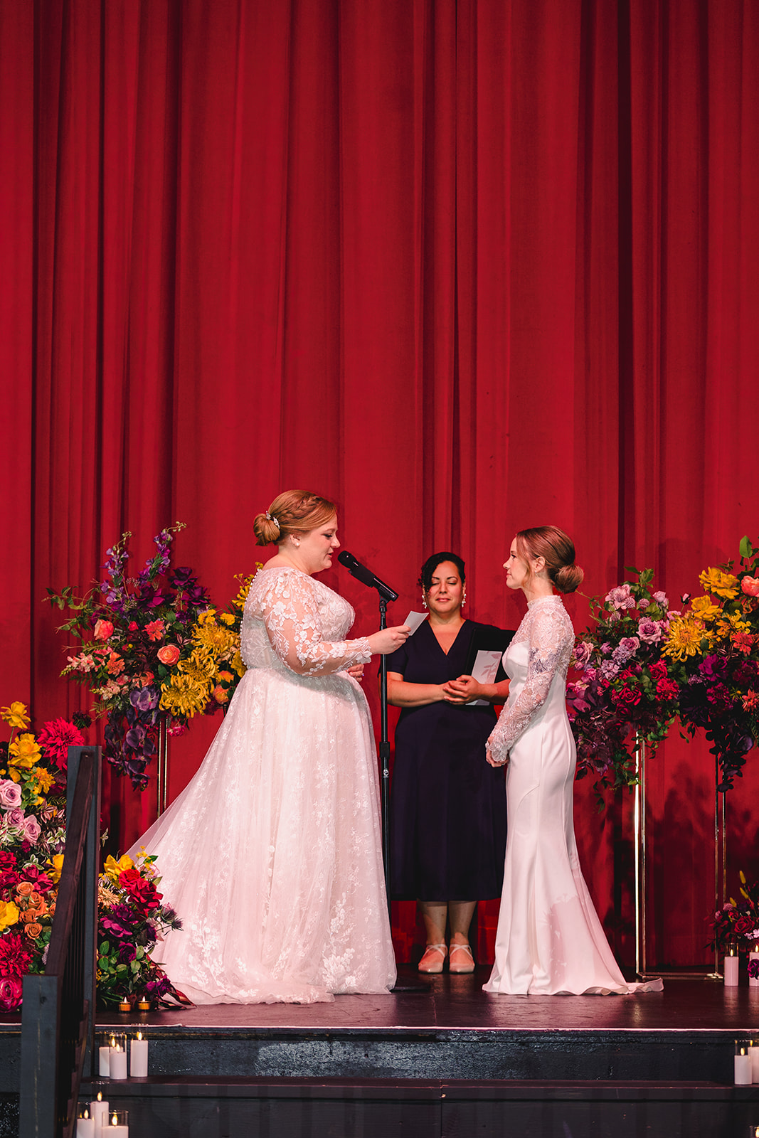 two brides at their wedding ceremony inside of the uptown theater in kansas city 