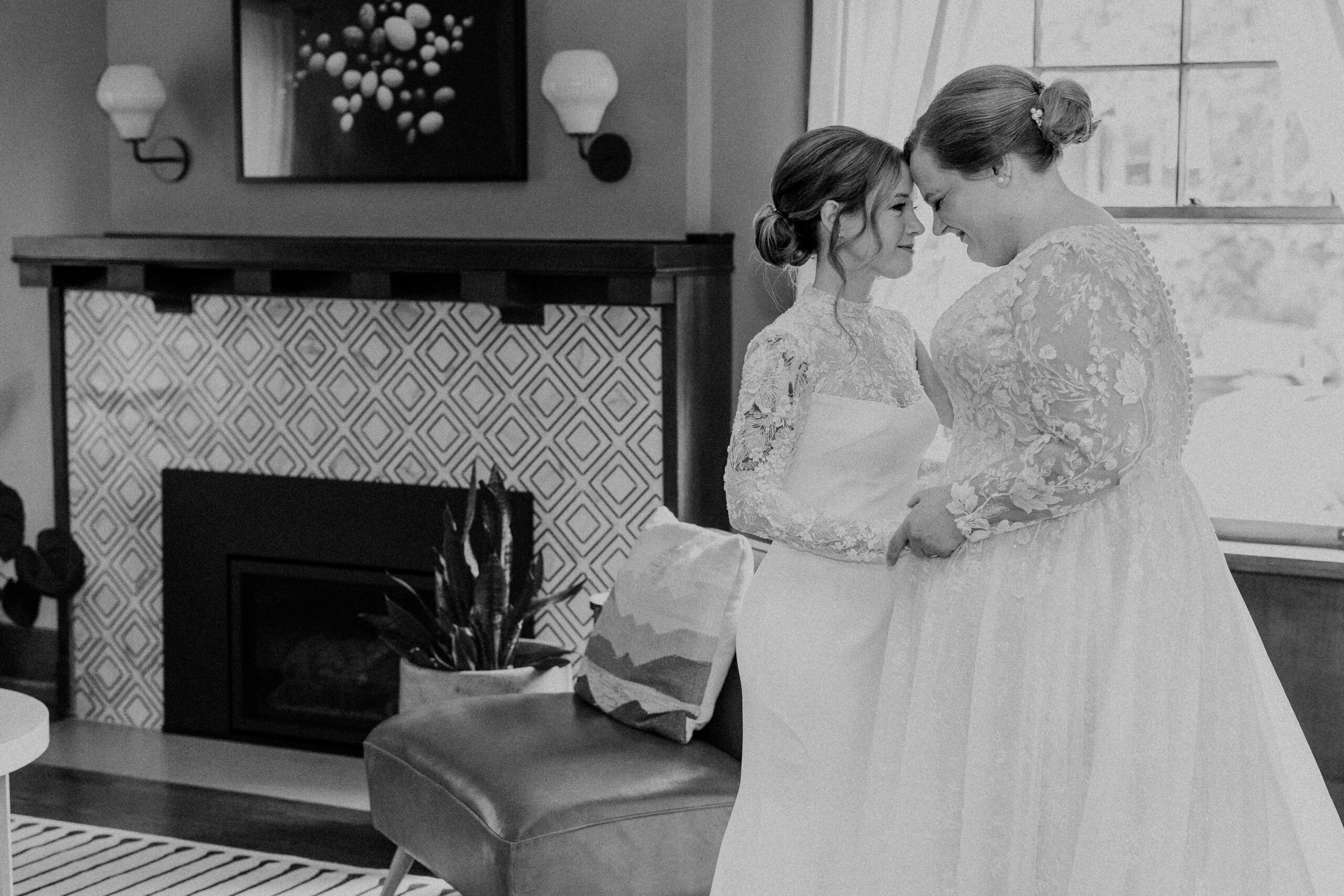 two brides taking wedding portraits together their heads are pressed together and they are holding hands 