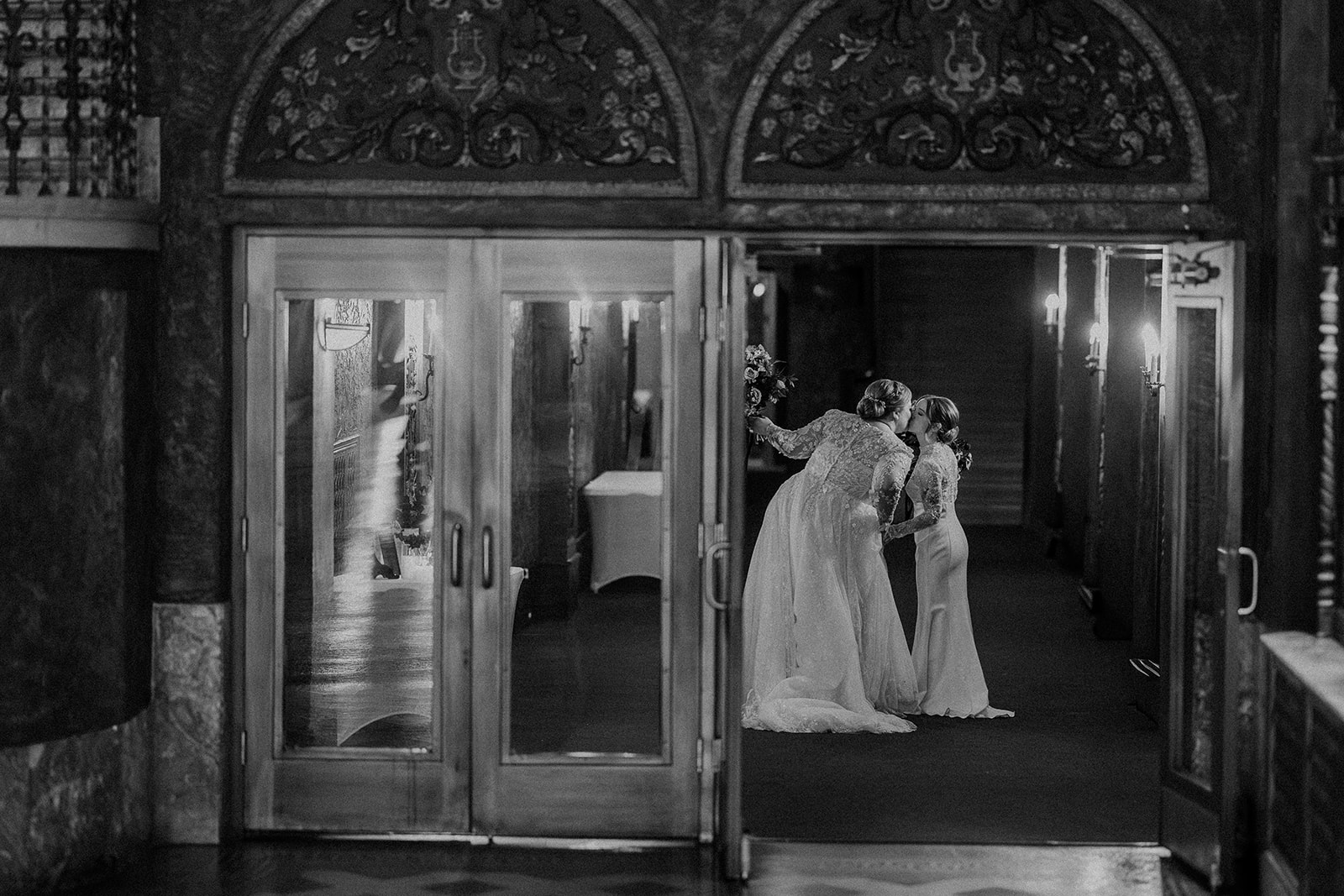 two brides kissing inside the uptown theater in kansas city 