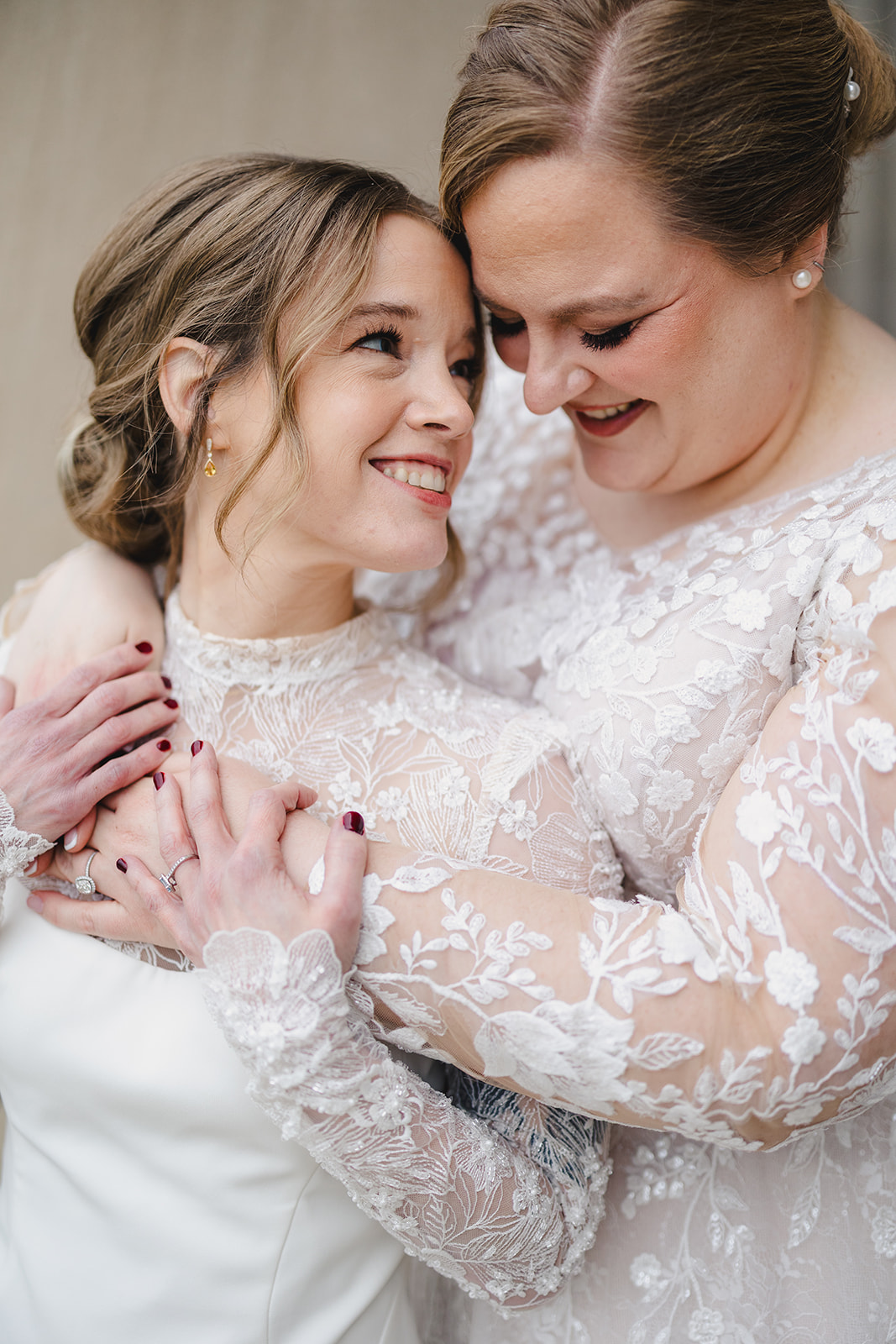 two brides taking wedding portraits together one bride has her arms wrapped around the other bride 