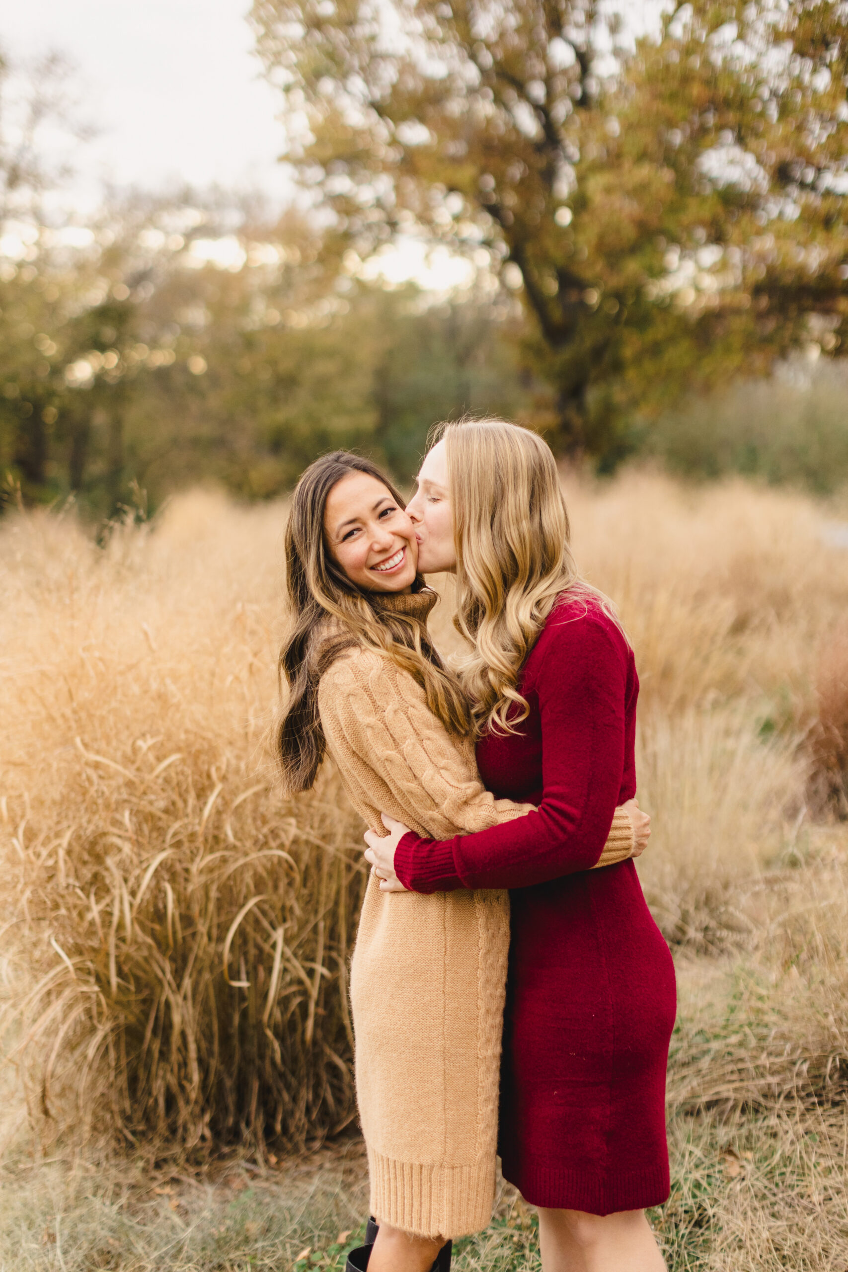 a woman embracing her partner and kissing her on the cheek during their fall engagement session 