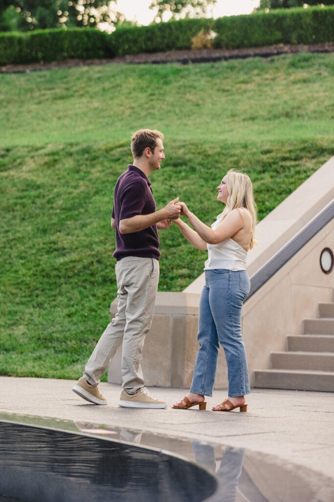 a couple holding hands next to the water and walking towards each otheer