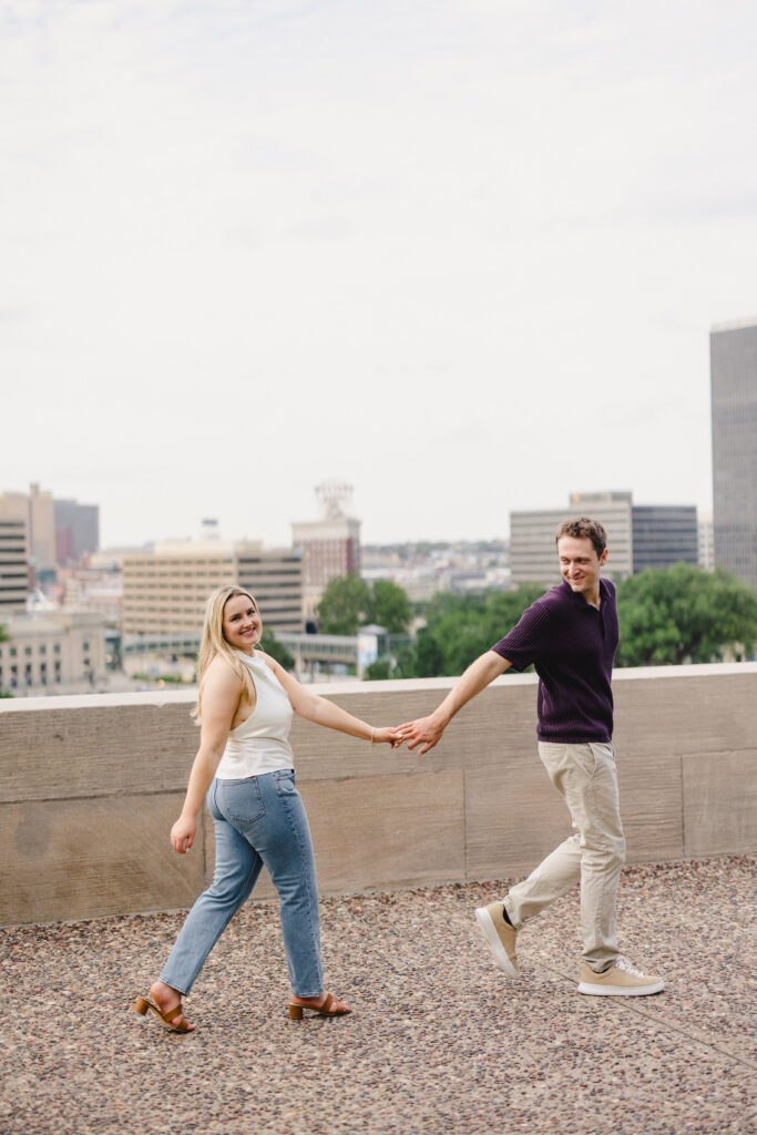 a couple walking hand in hand together on a rooftop 