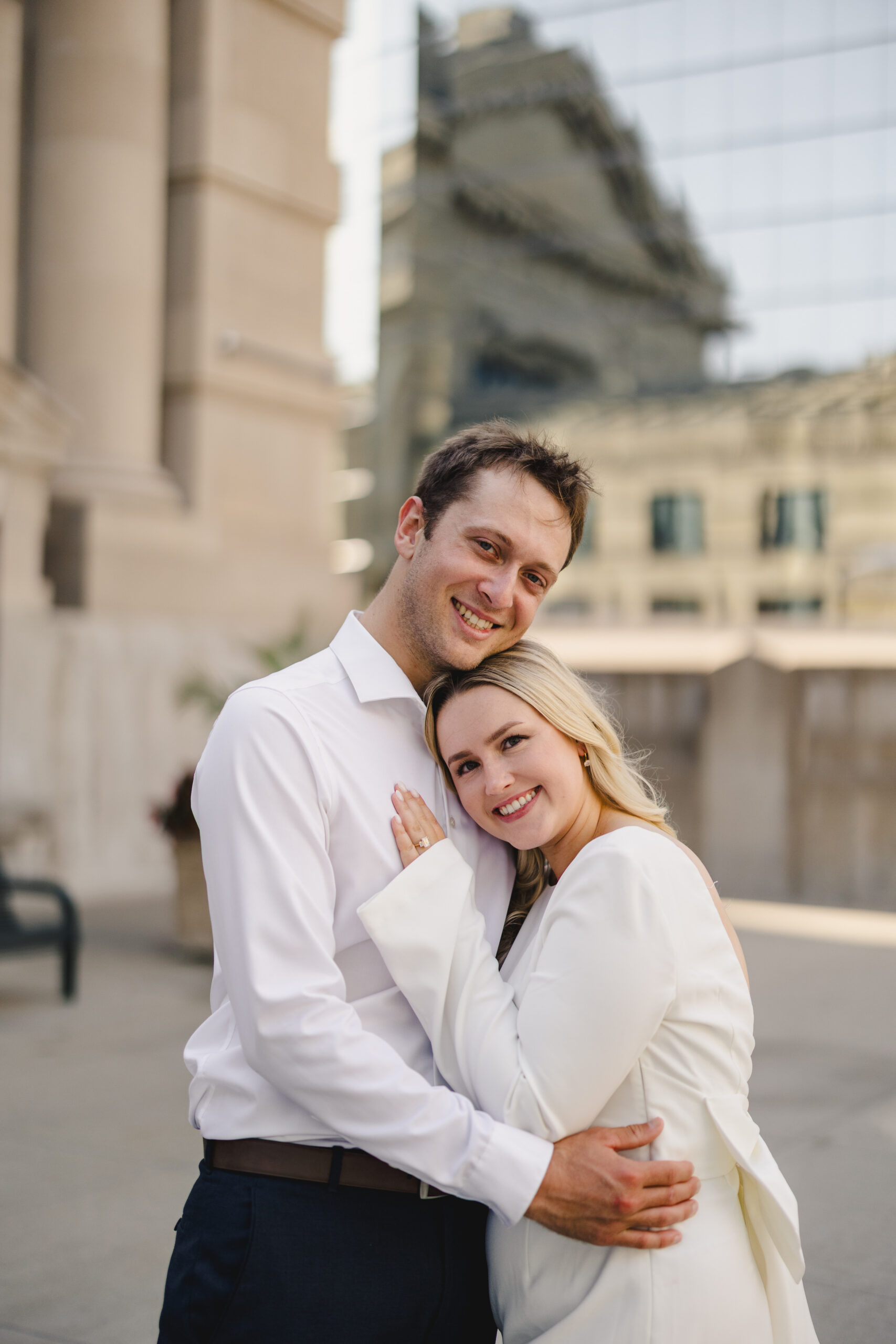 a couple embracing one another during their engagement session and smiling 