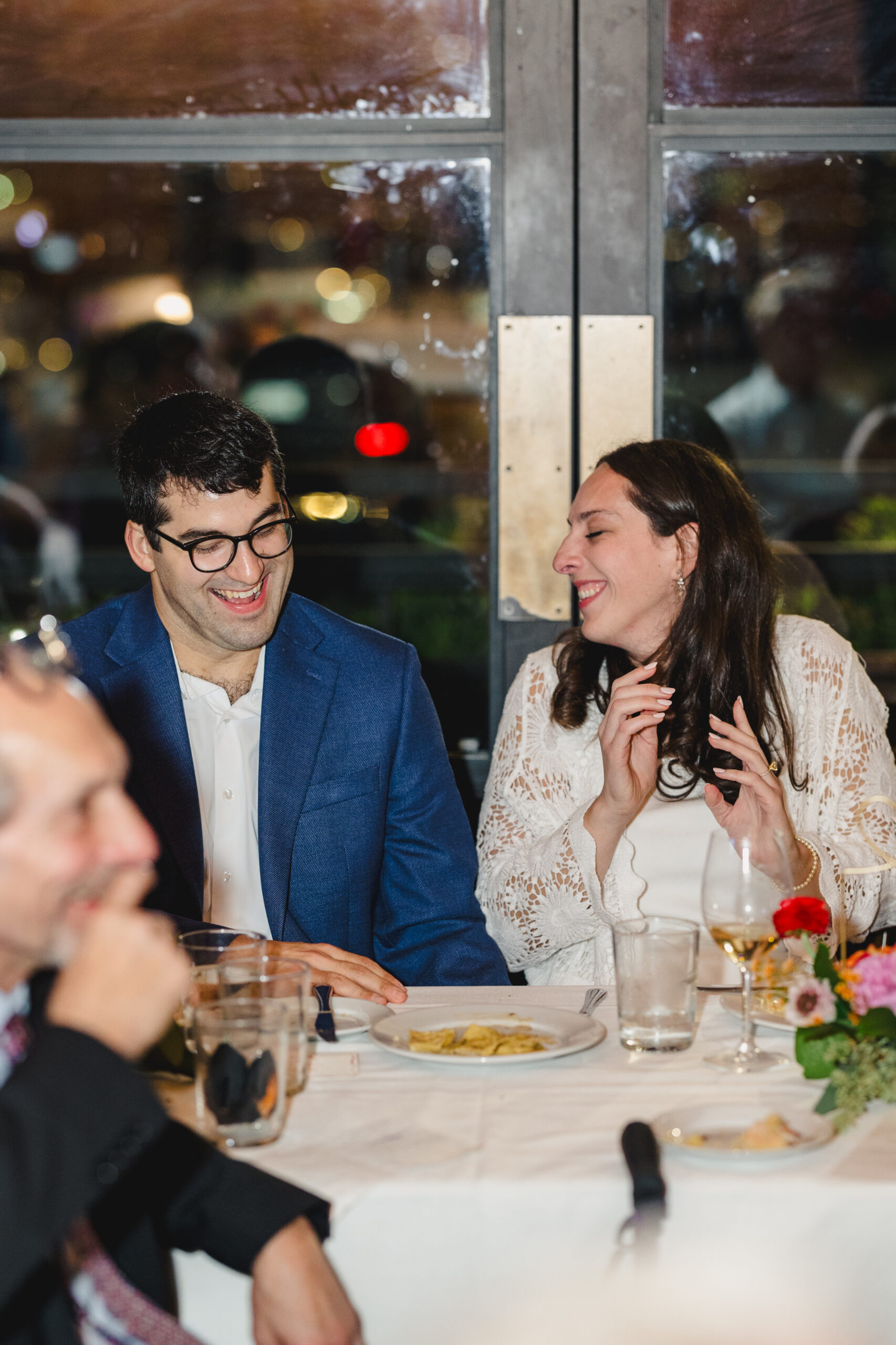 a copule laughing with each other at their wedding rehearsal dinner in lidia's in kansas city 