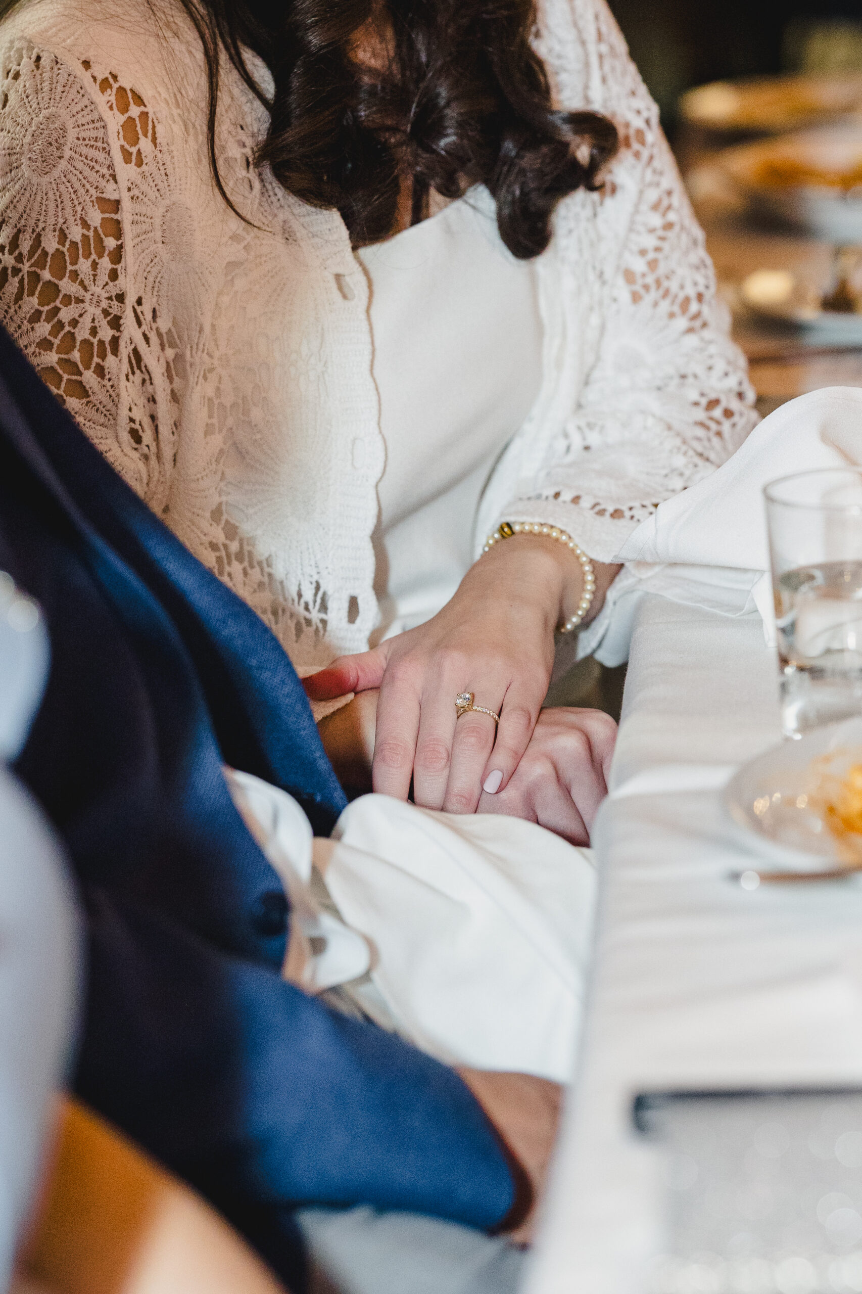 a couple holding hands at their wedding rehearsal dinner
