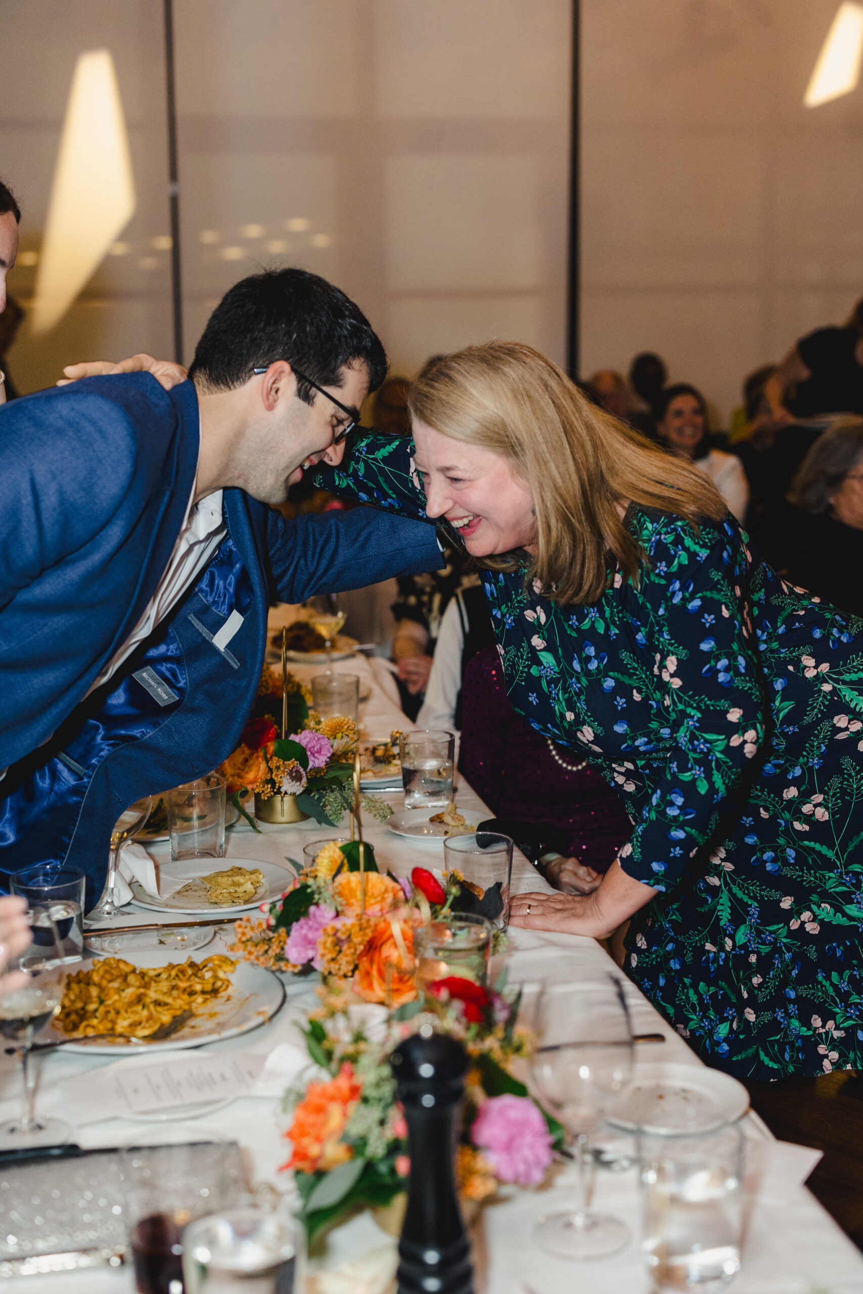 a soon to be groom hugging guest at his wedding rehearsal dinner 