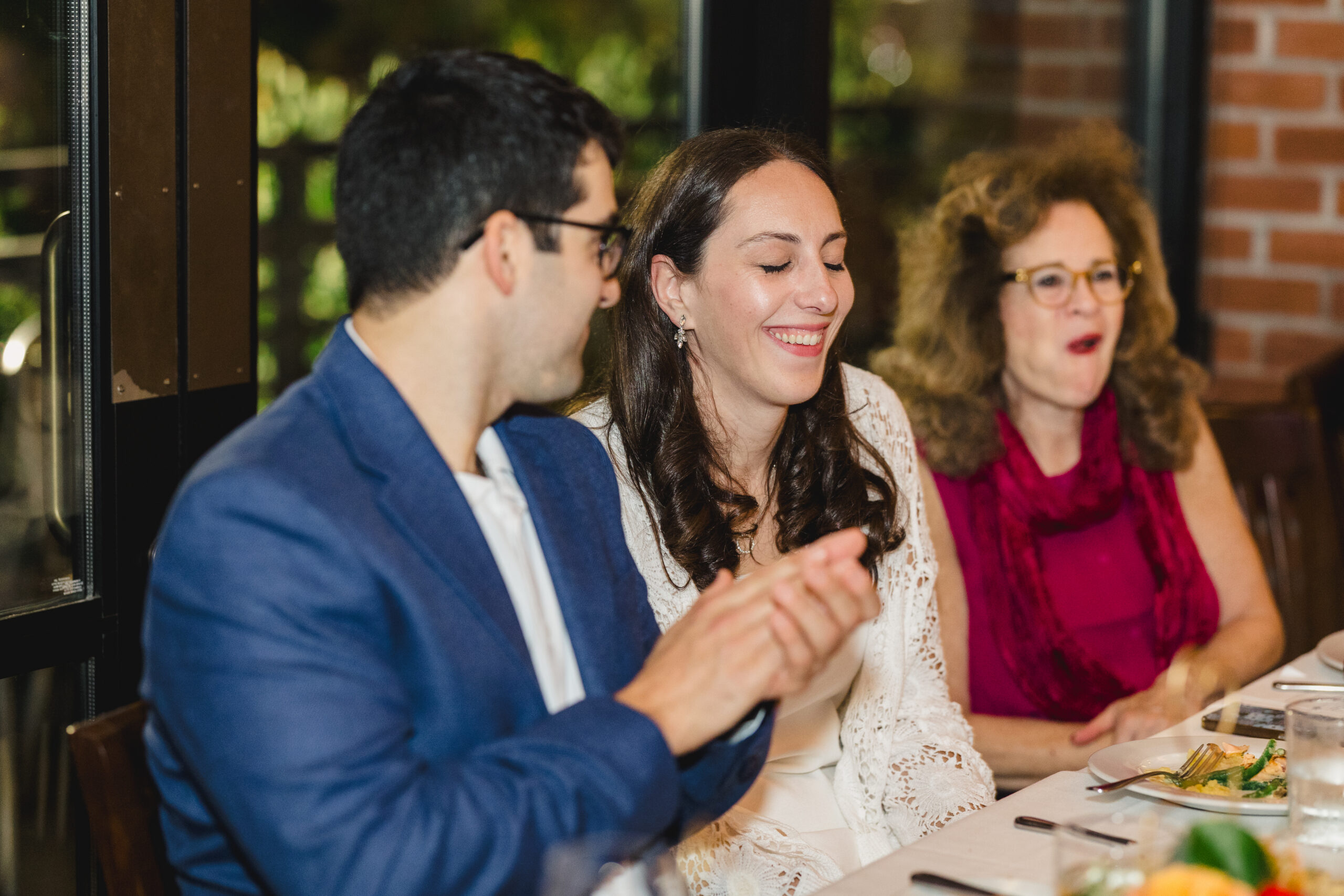 a couple at their rehearsal dinner laughing with each other 
