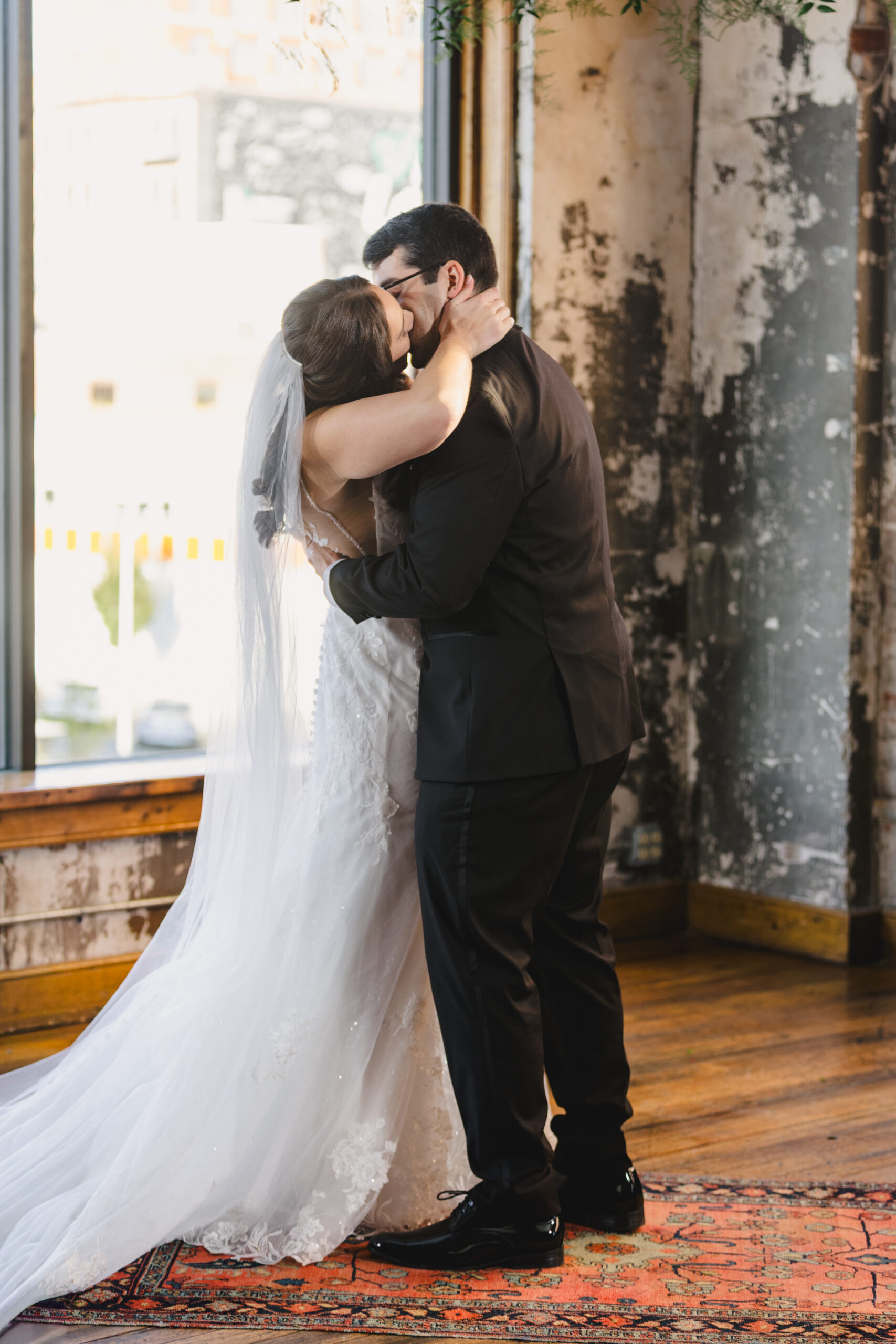 a couple kissing after their wedding ceremony inside the bauer in kansas city 