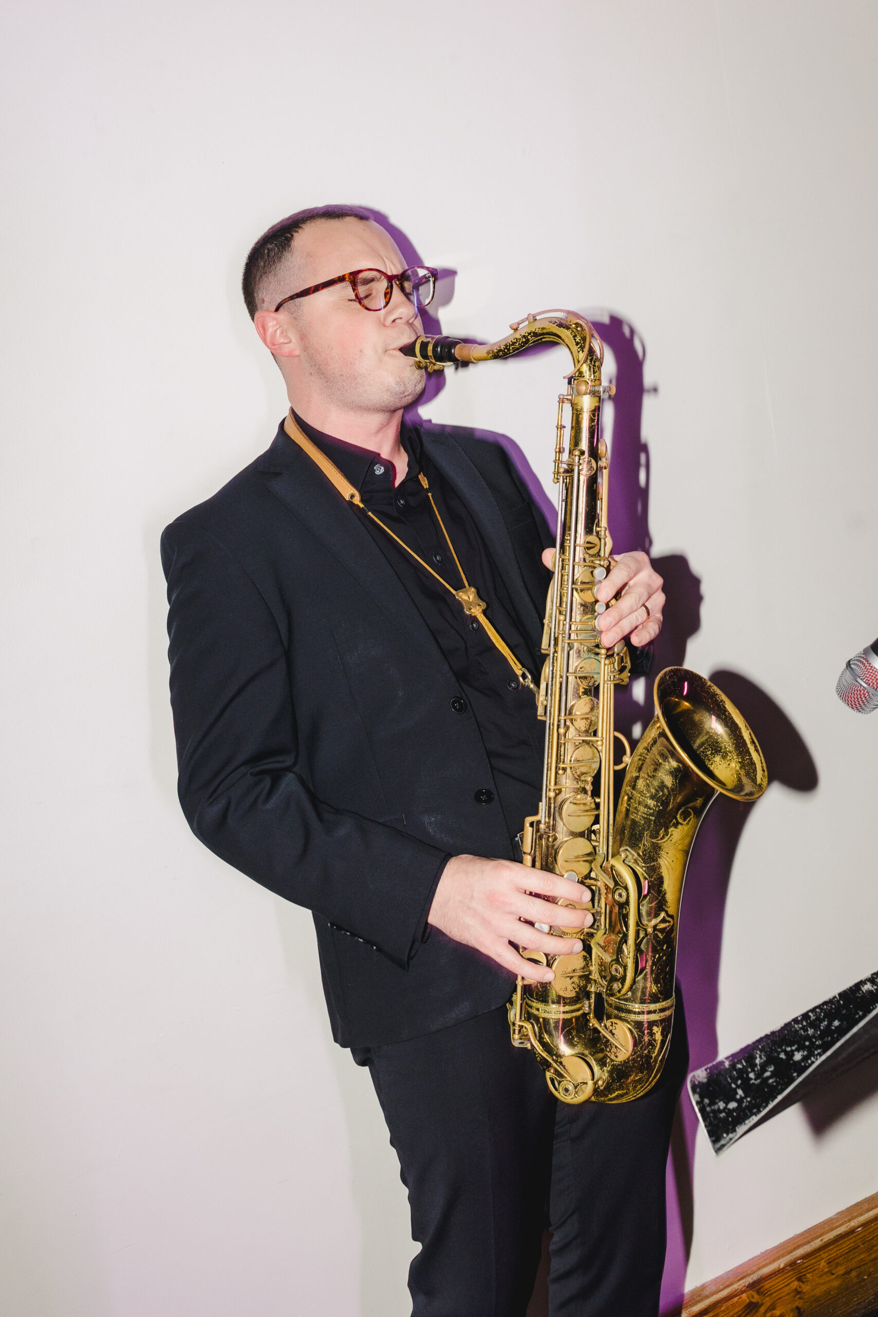a man playing a saxaphone at a wedding reception 