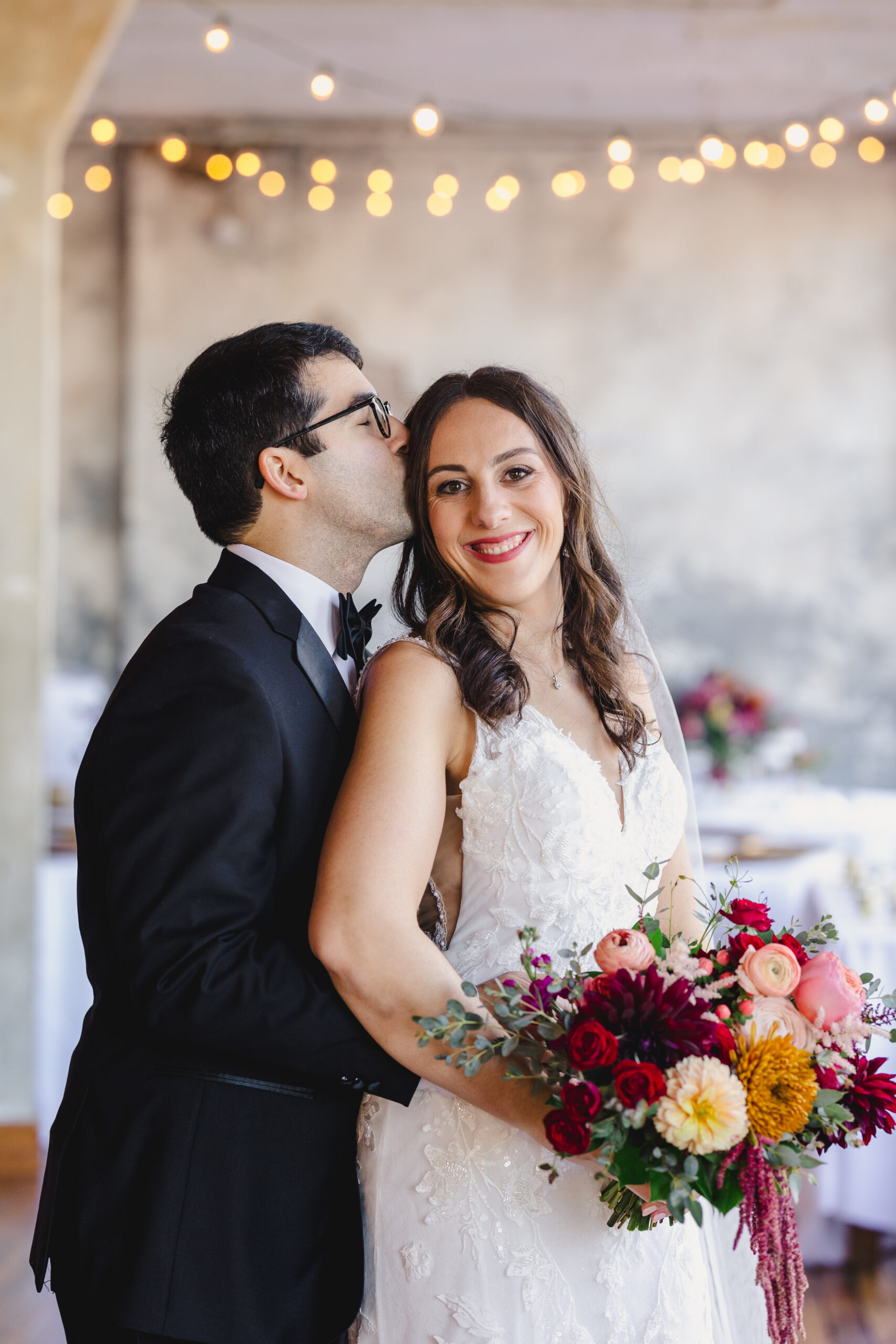 a couple taking wedding portraits inside the bauer in kansas city the man is kissing his bride who is smiling