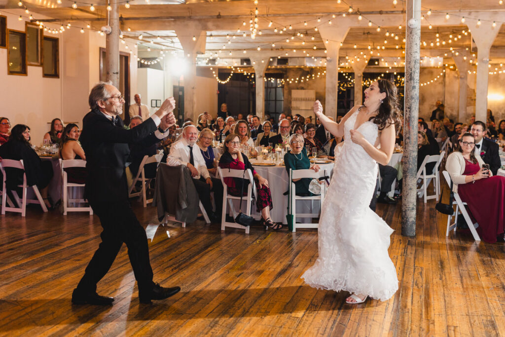 A newlywed dancing with their father at their wedding reception 
