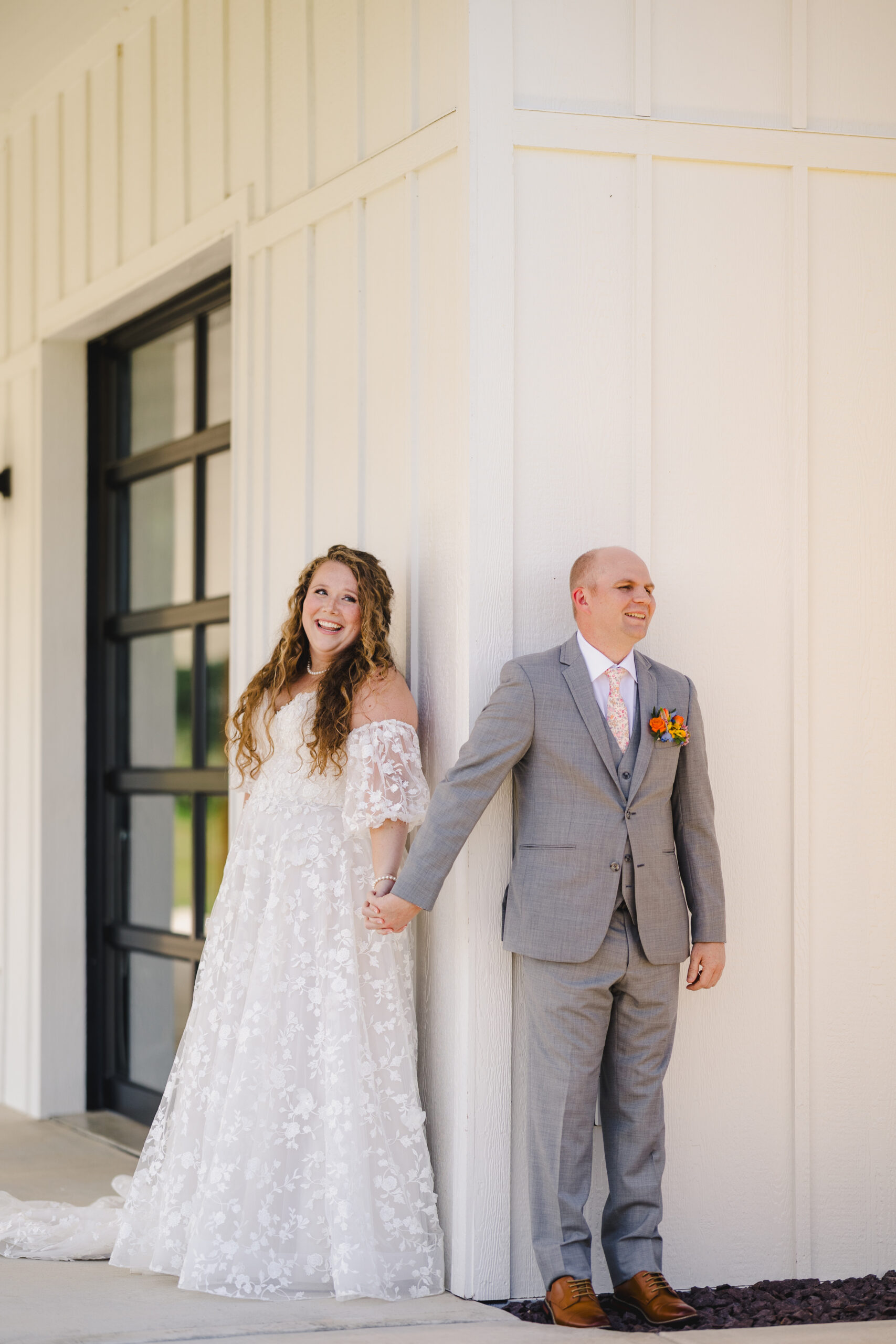 a bride and groom holding hands before sharing a first look