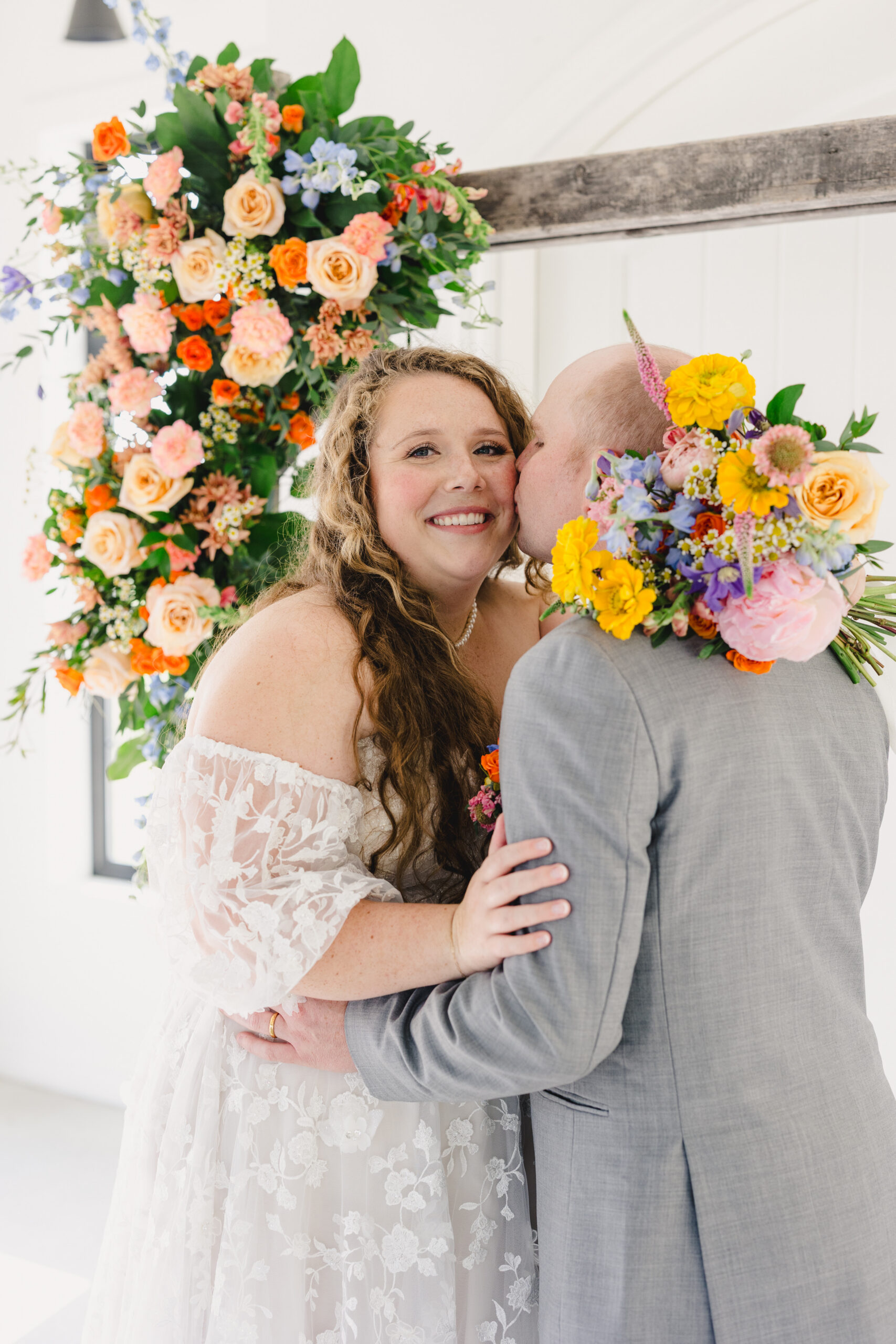 a groom kissing his bride on the cheek