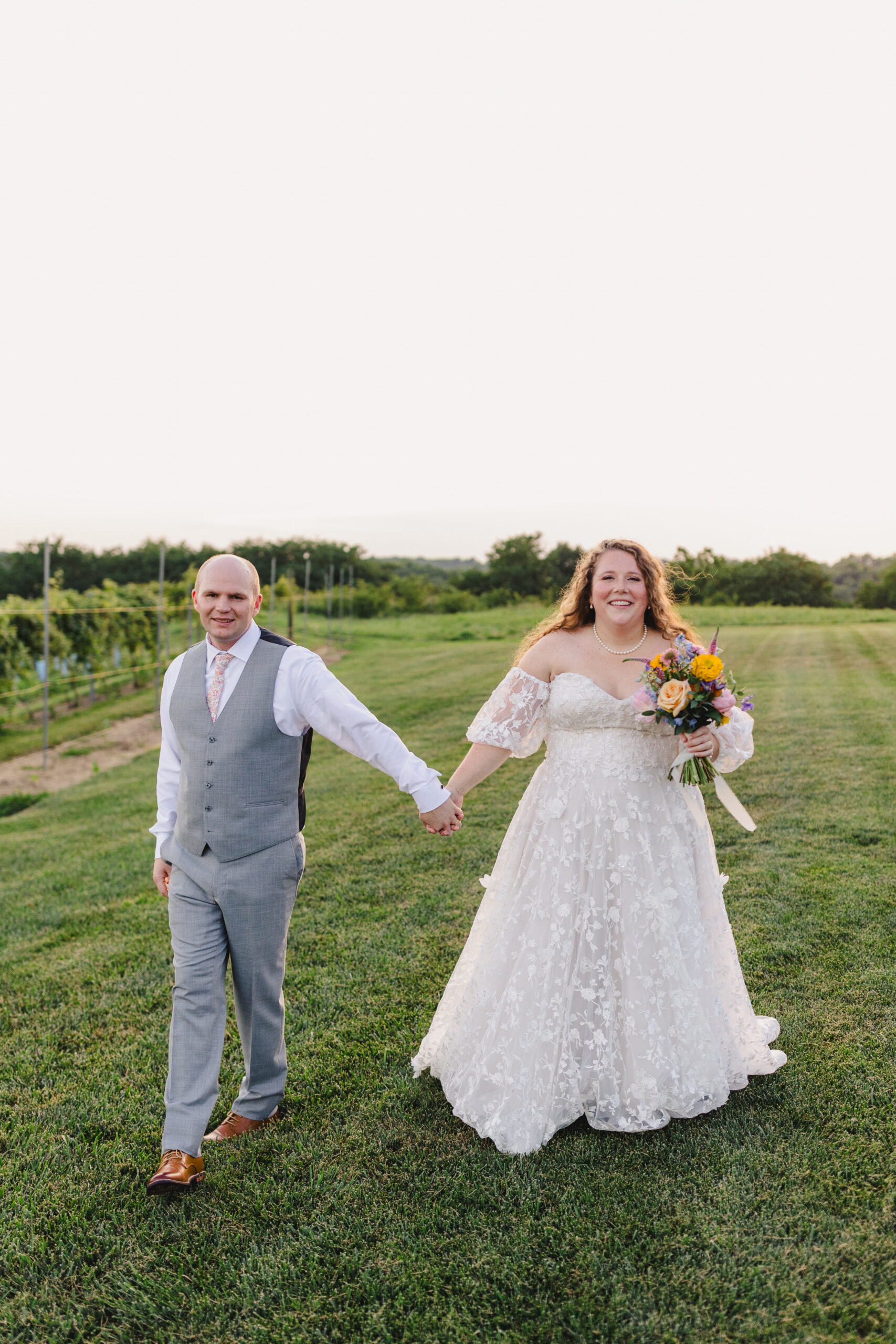 a bride and groom taking a wedding portrait on the lawn