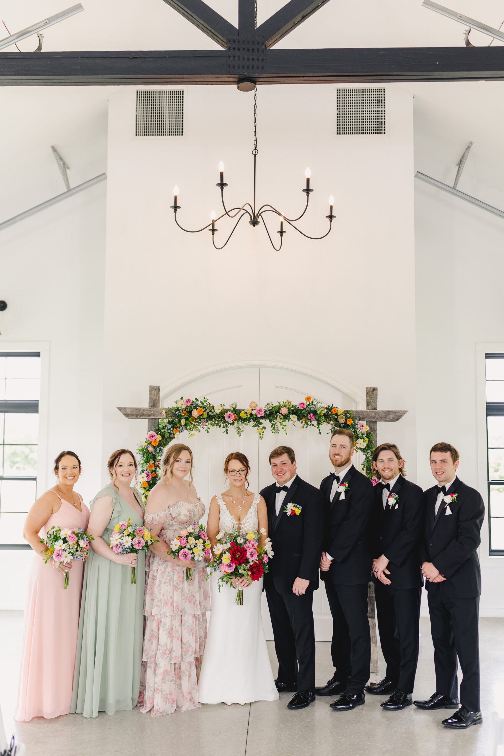 a bride and groom taking wedding portraits with their wedding party 