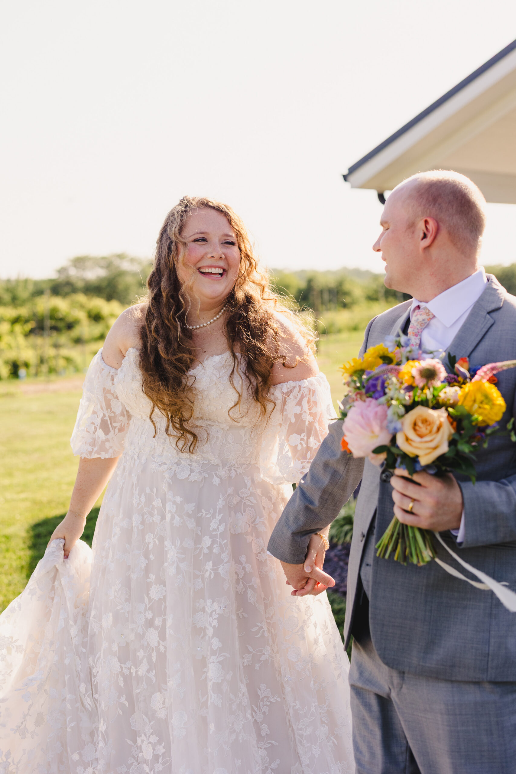 a bride and groom holding hands and taking sunset wedding photos