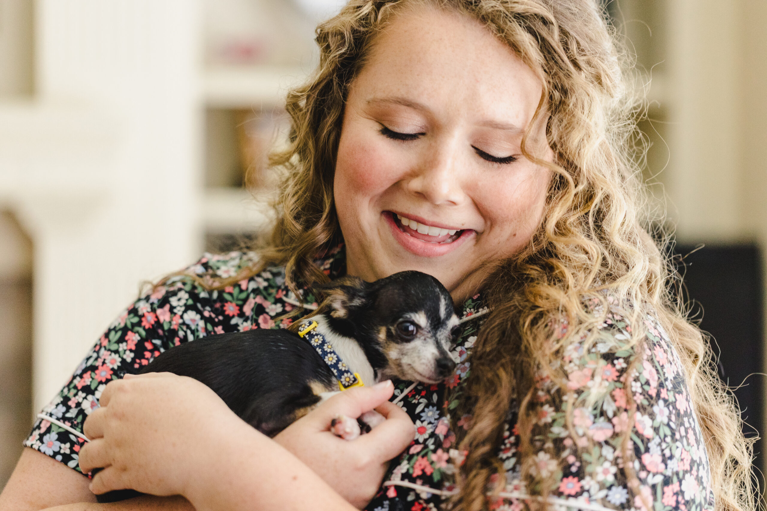 a bride holding her chihuahua as she gets ready for her wedding 