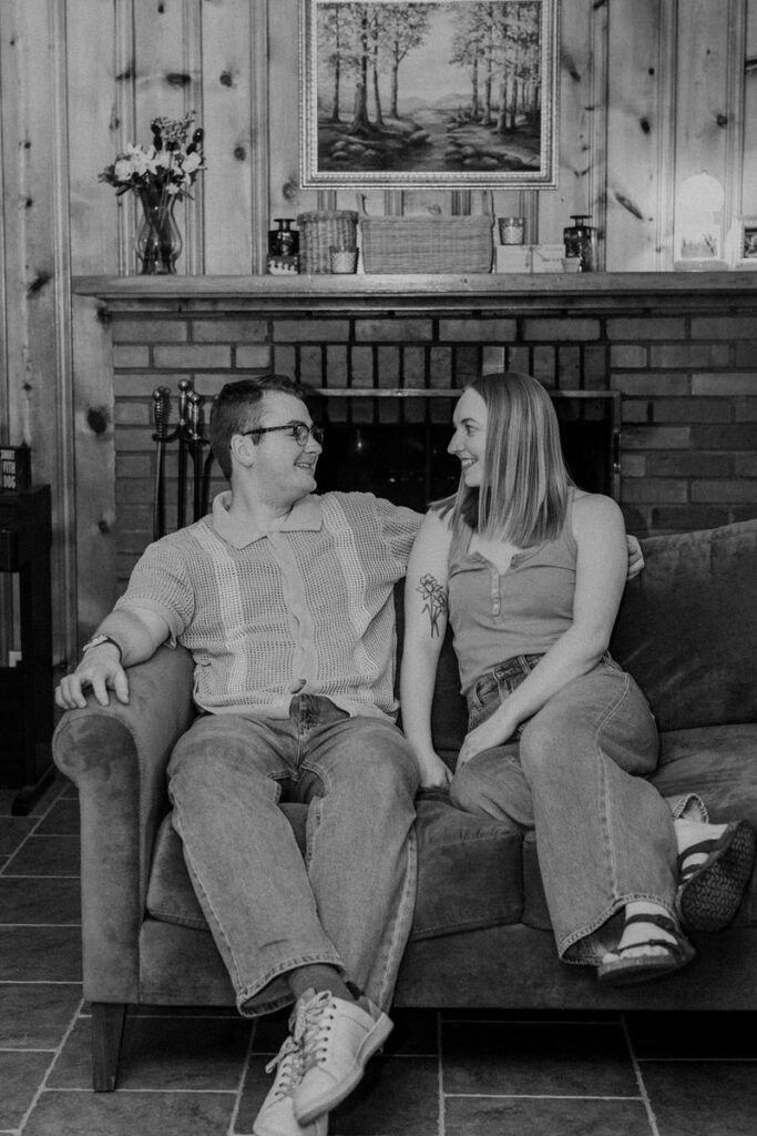 a couple sitting on the couch together laughing