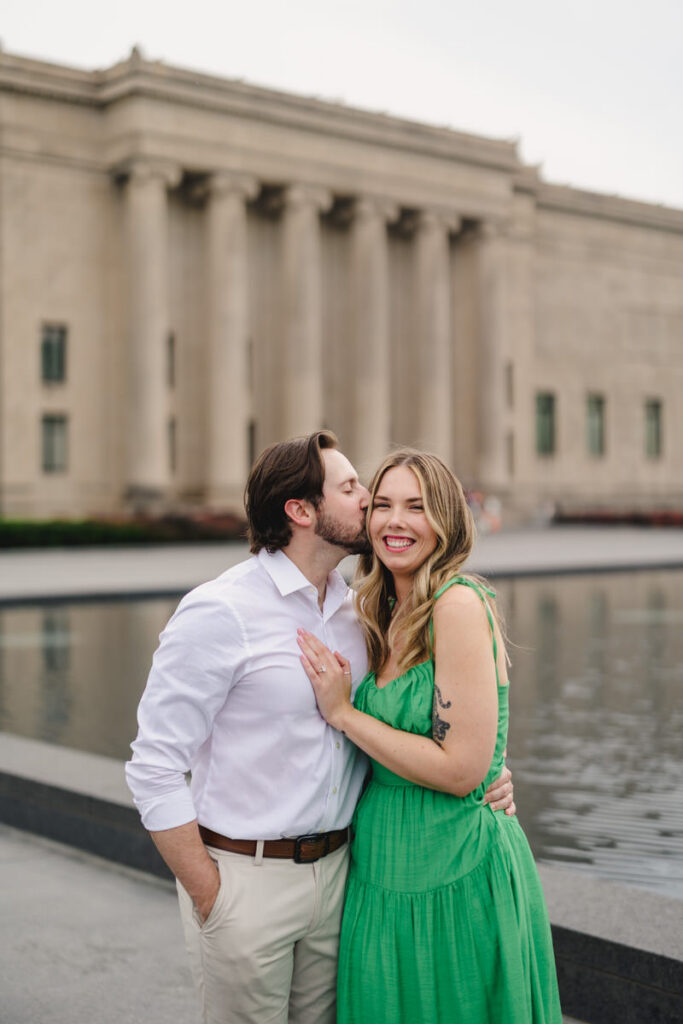 A person with their arm around their partner as they kiss their head