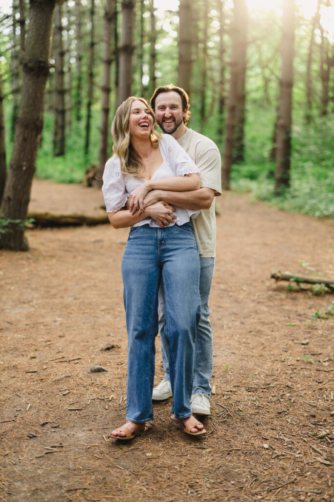 A person hugging their partner from behind as they laugh