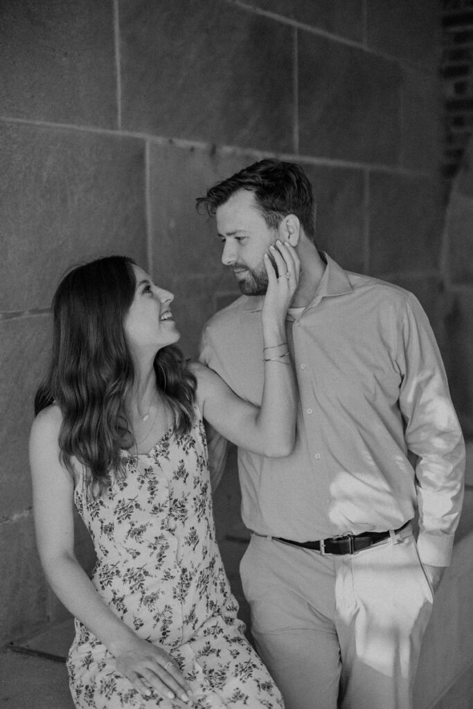 A person sitting next to their partner reaching their hand up to their face