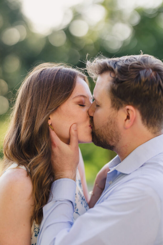 A person with their hands gently on their partner's face as they kiss