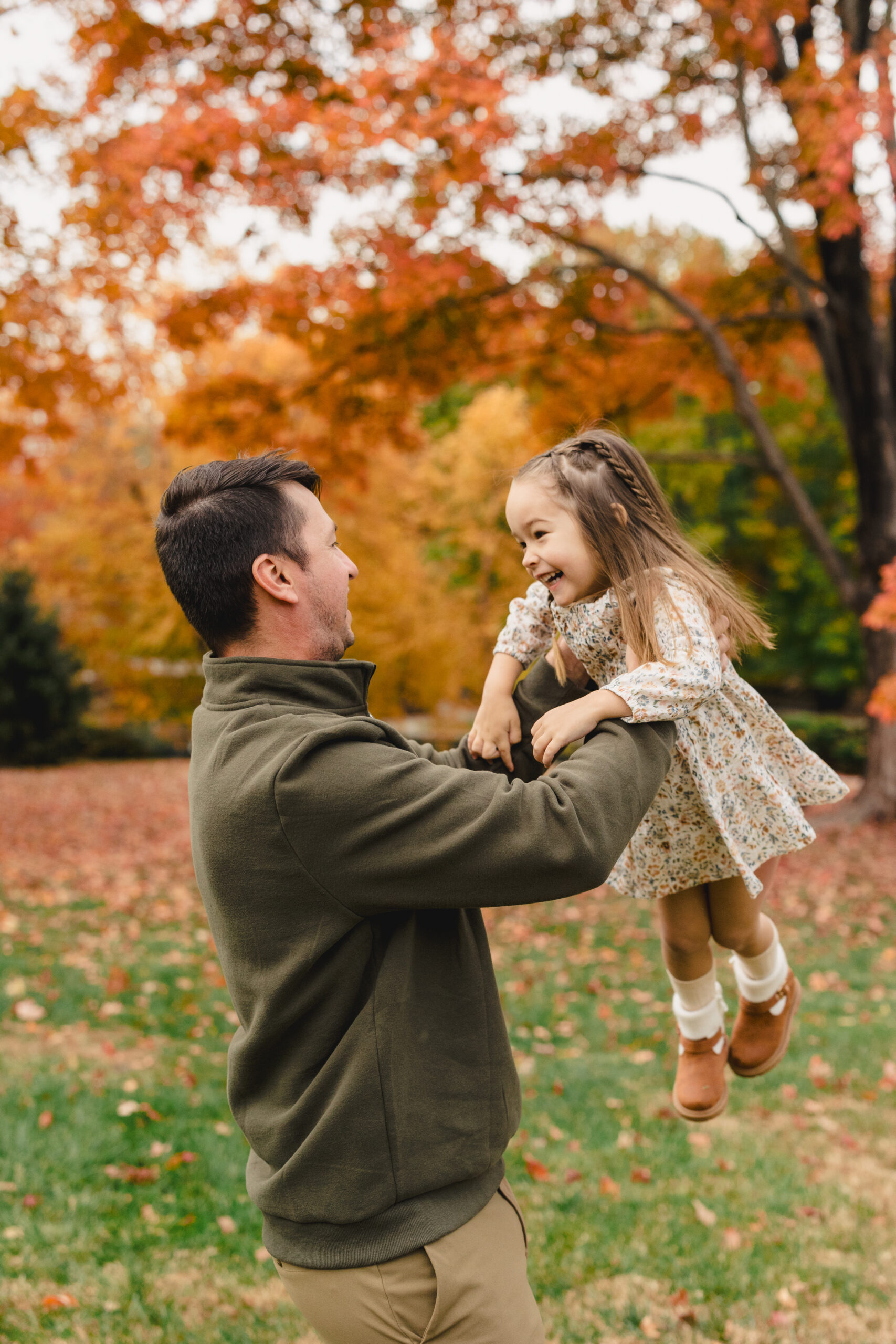 a father holding his daughter in a park