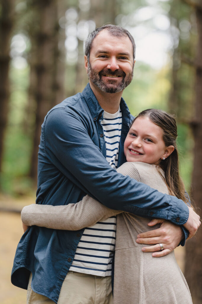 A parent hugging their child as they both smile 