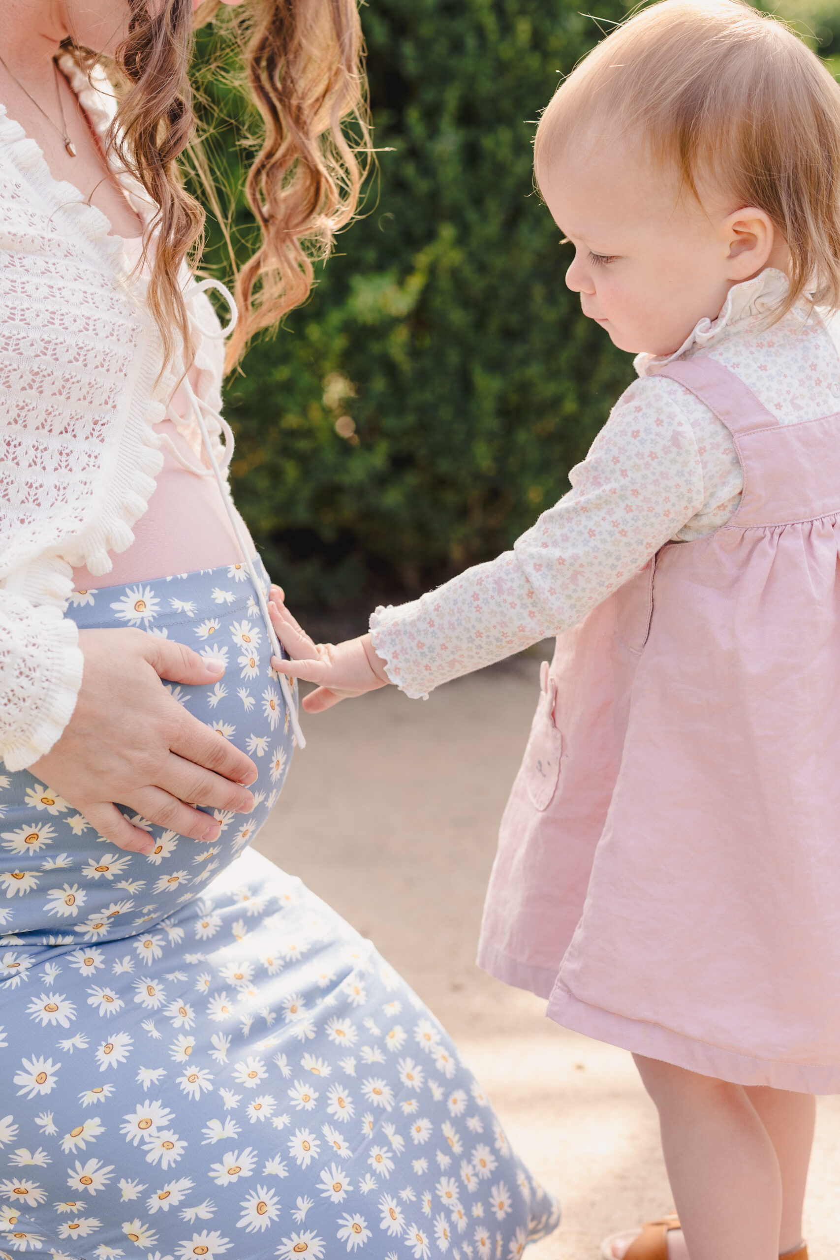 a daughter touching her mother's belly 